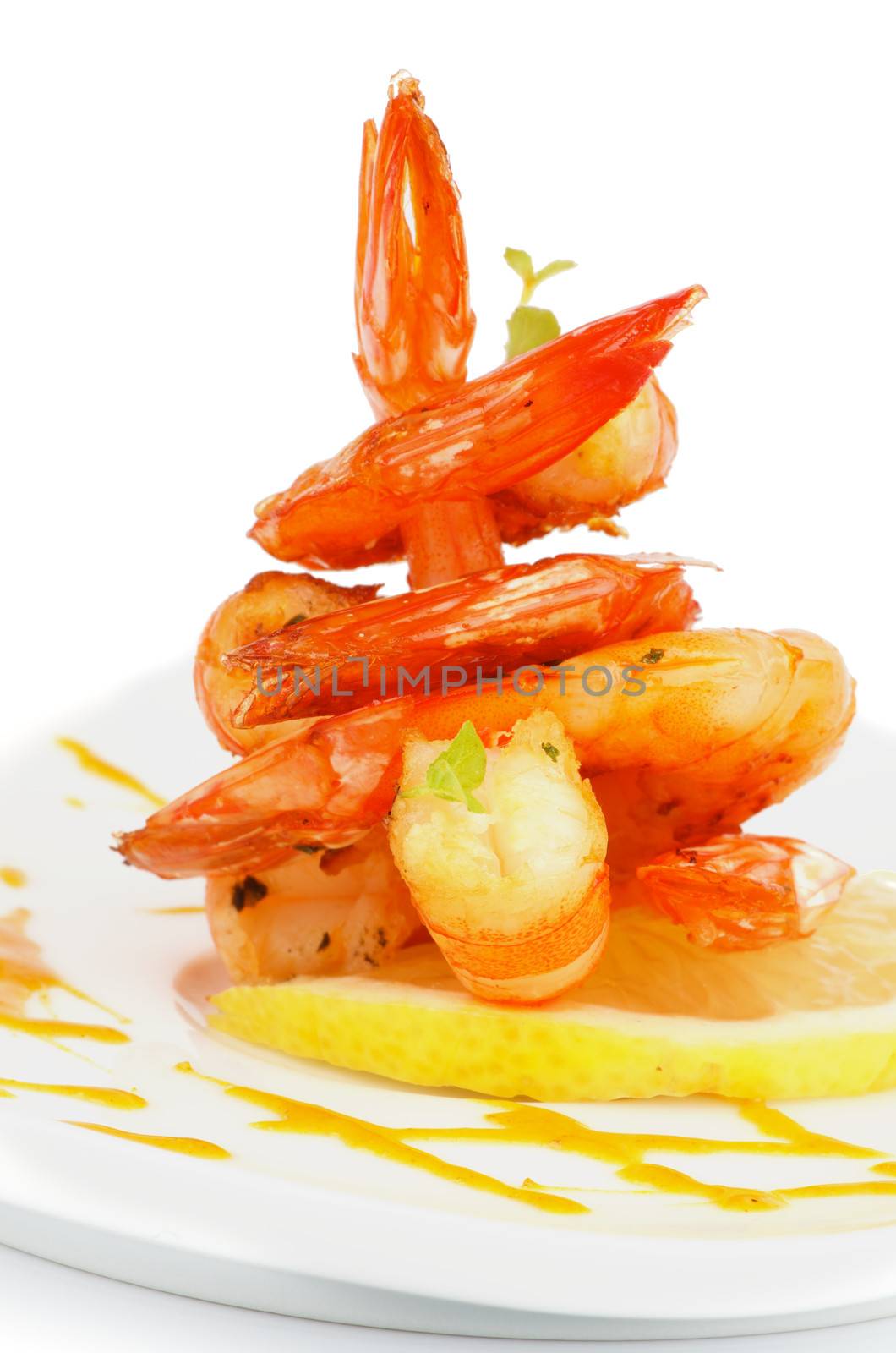 Gourmet Fried Shrimps Garnished with Lemon, Mustard Sauce and Thyme closeup on White plate isolated on white background