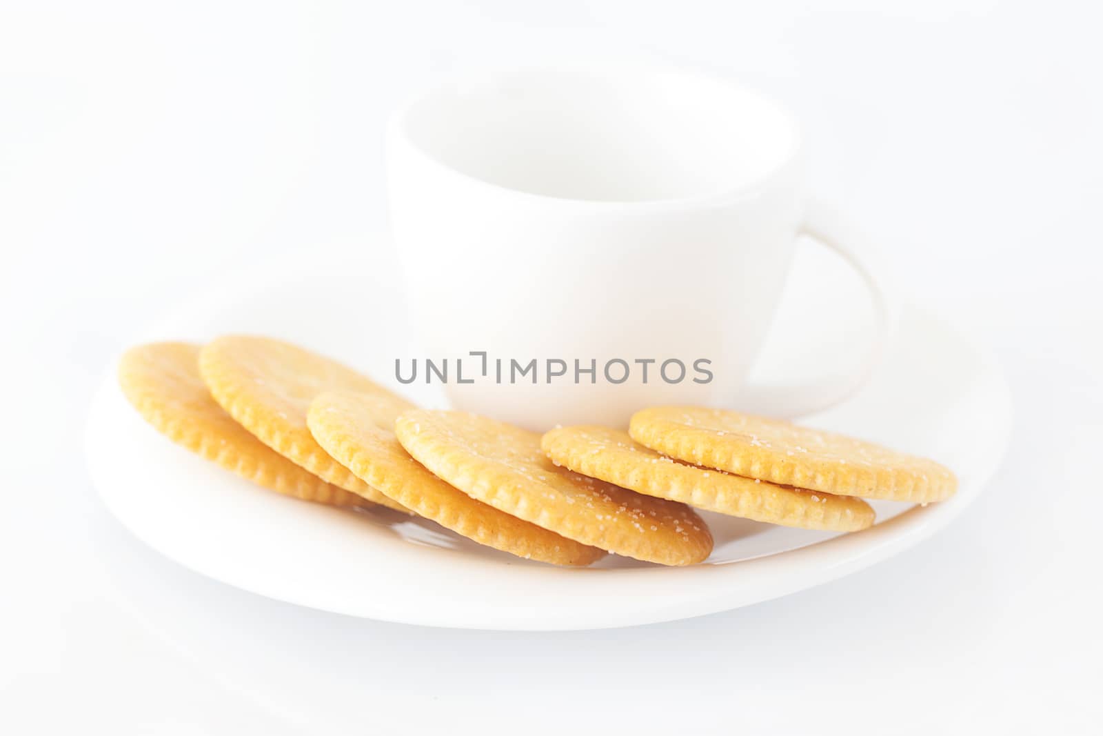 white cup with saucer and crackers