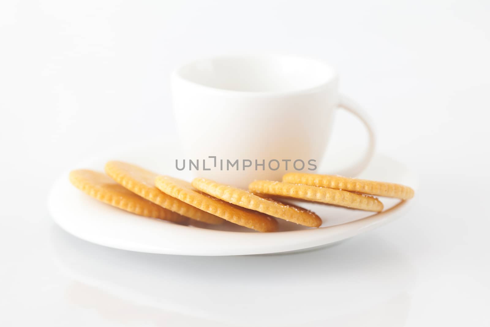 white cup with saucer and crackers by jannyjus