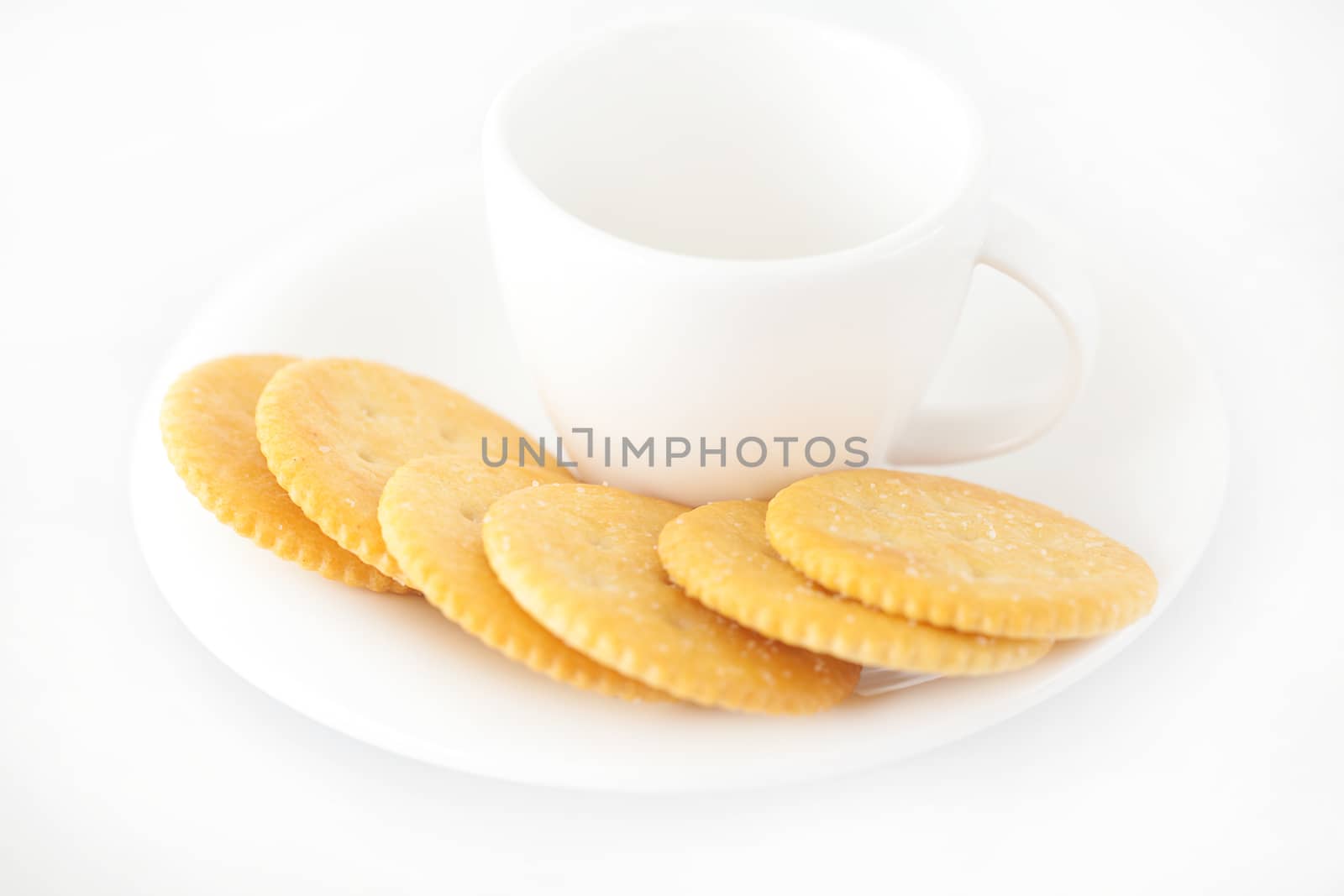 white cup with saucer and crackers by jannyjus