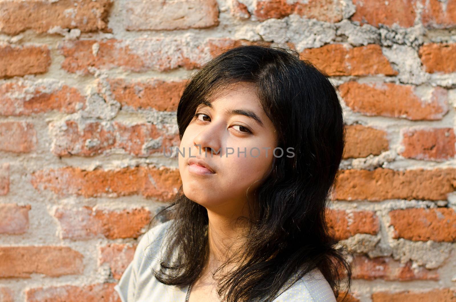 Pretentious asian girl over brick wall