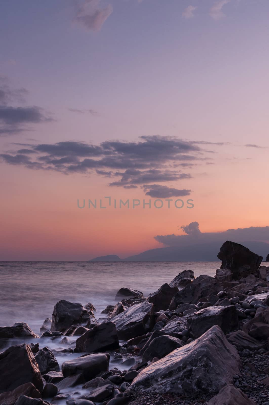 Large boulders on the beach during a beautiful sunset.