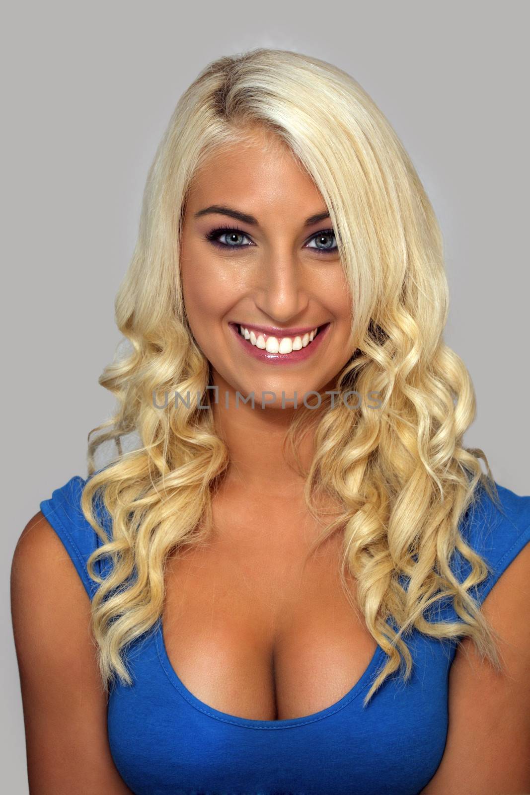 Close-up of an extraordinarily beautiful and voluptuous young blonde with a bright, warm smile.