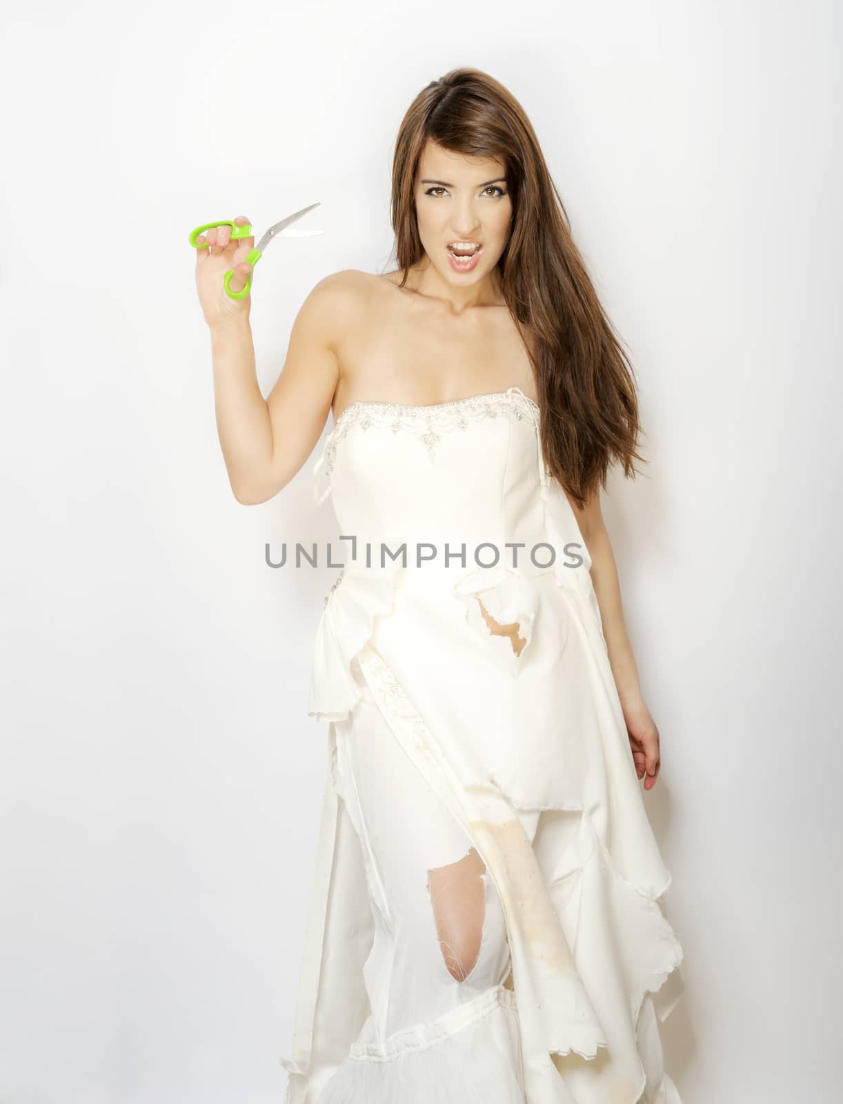 sexy woman in ripped and cut wedding dress holding scissors