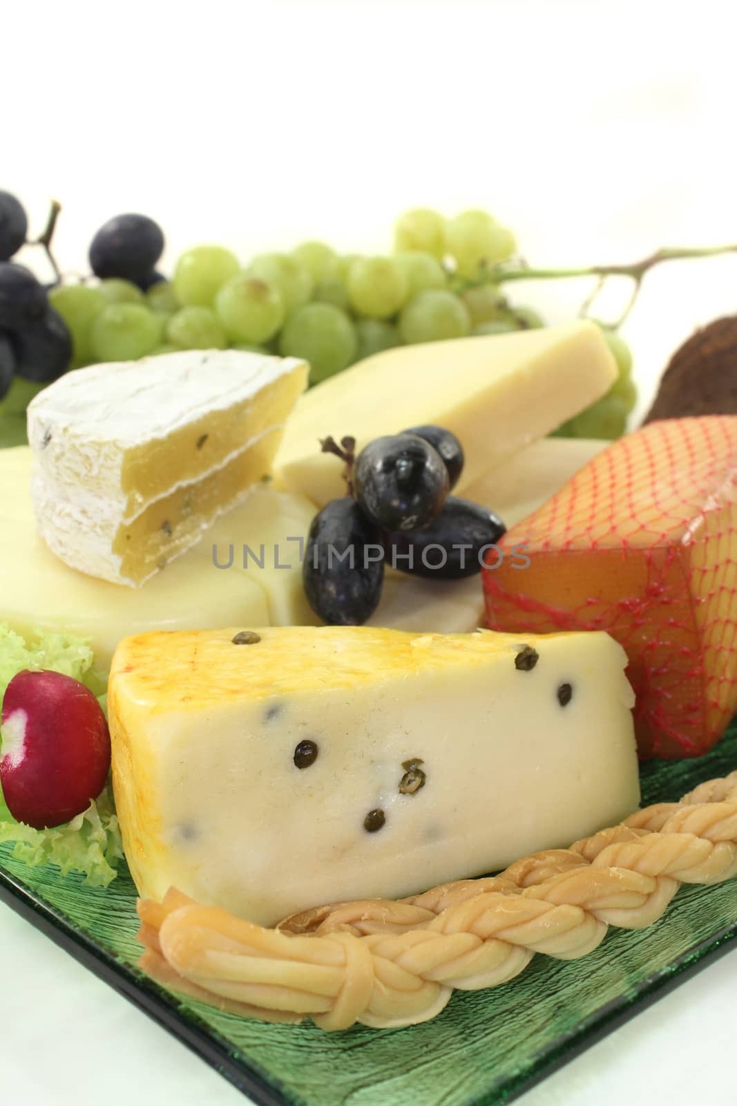 different types of cheese on a green glass plate