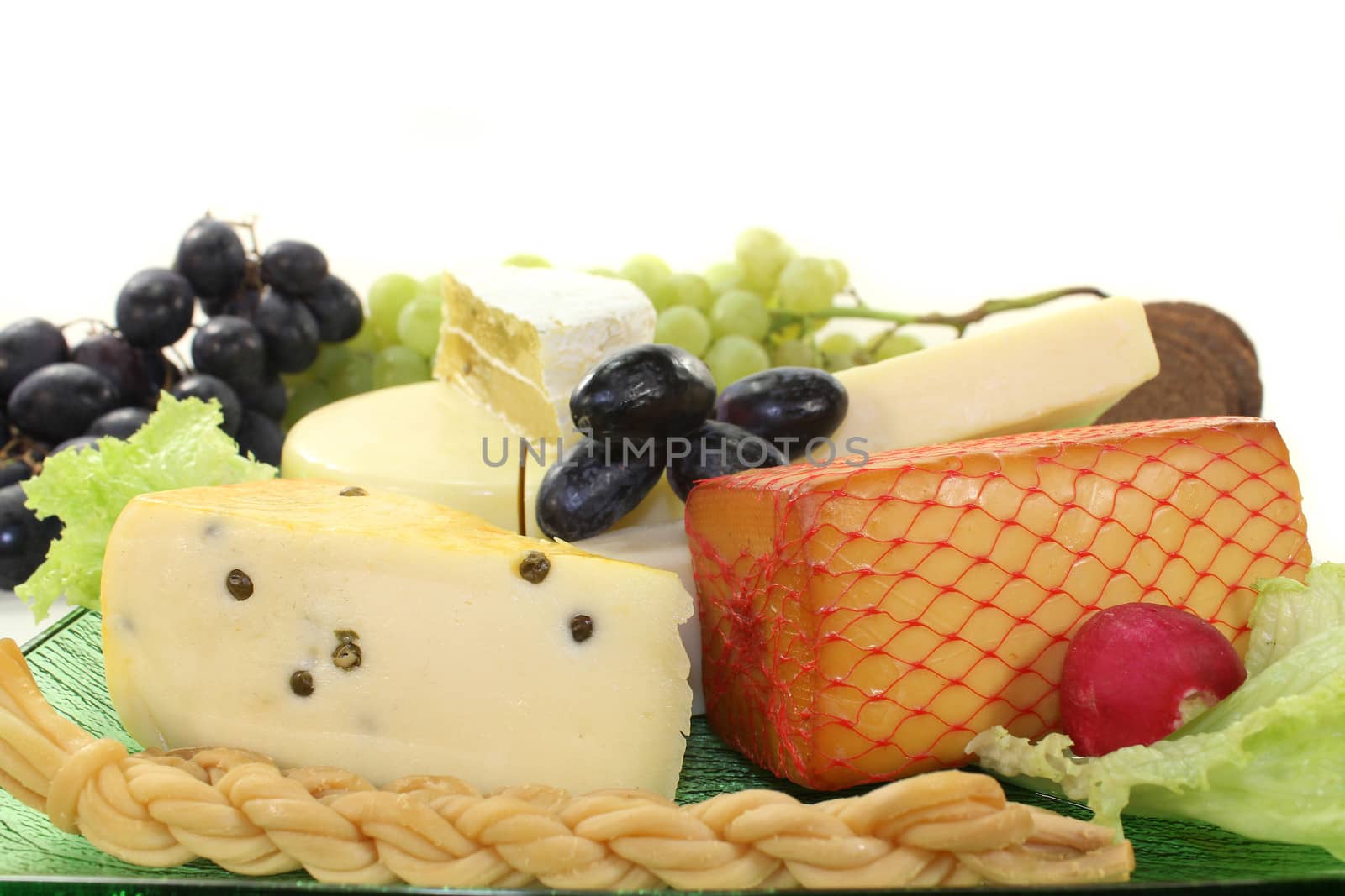 different types of cheese on a green glass plate