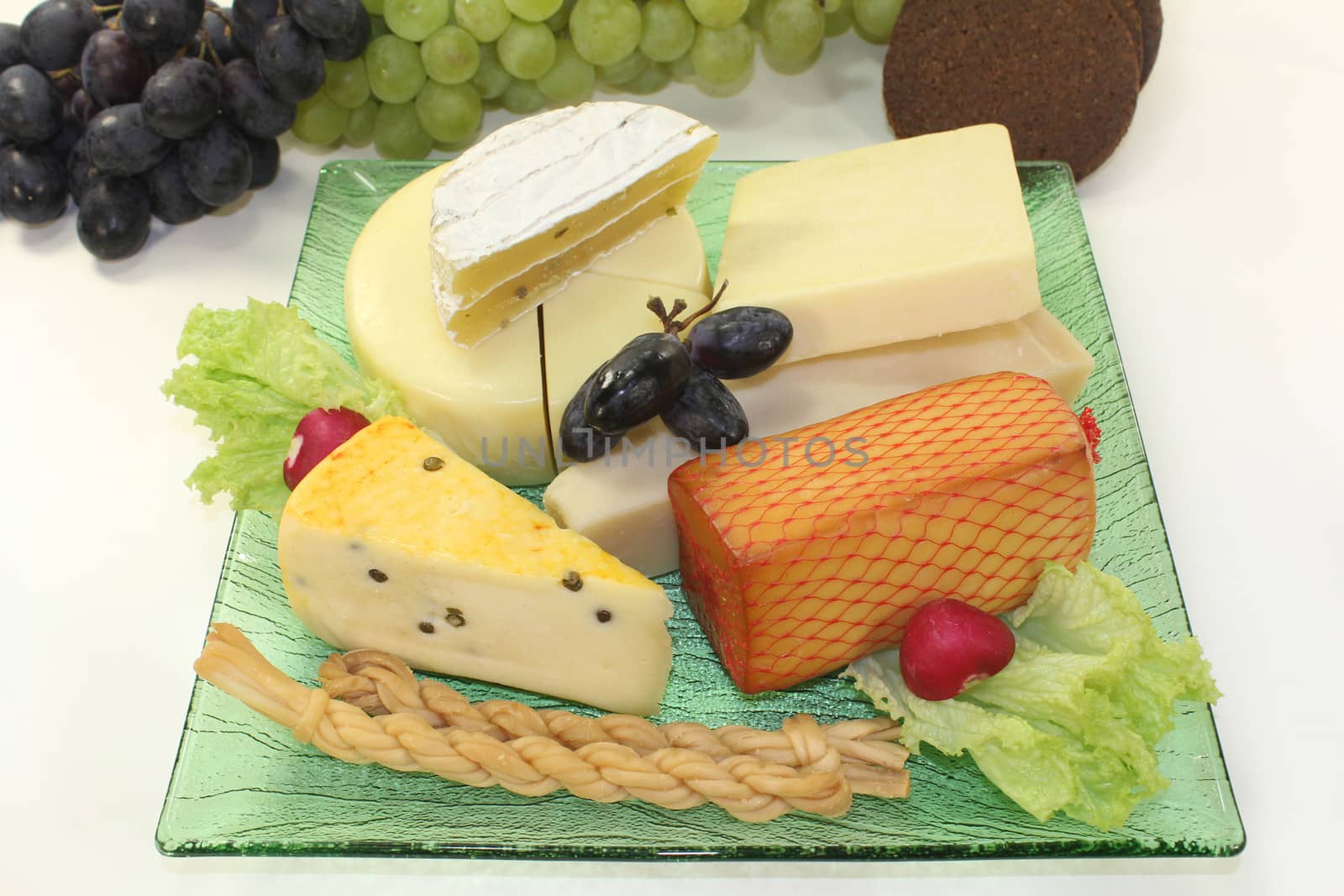 different types of cheese on a green glass plate