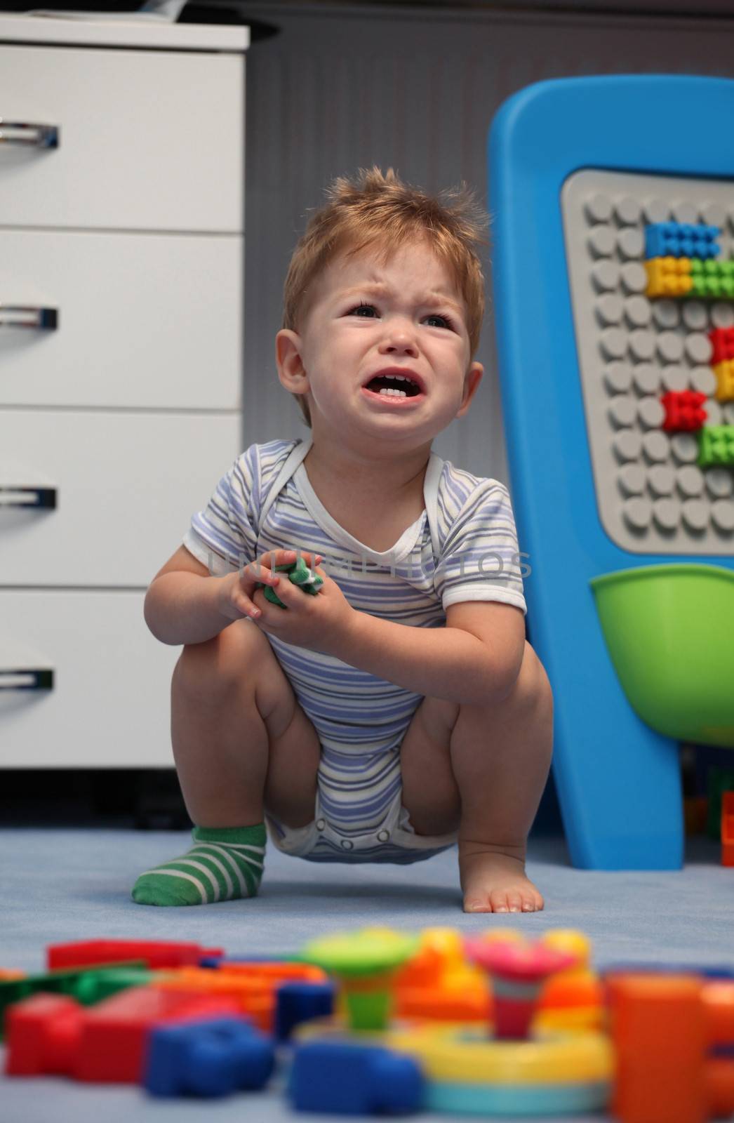 A baby boy crying in children's room