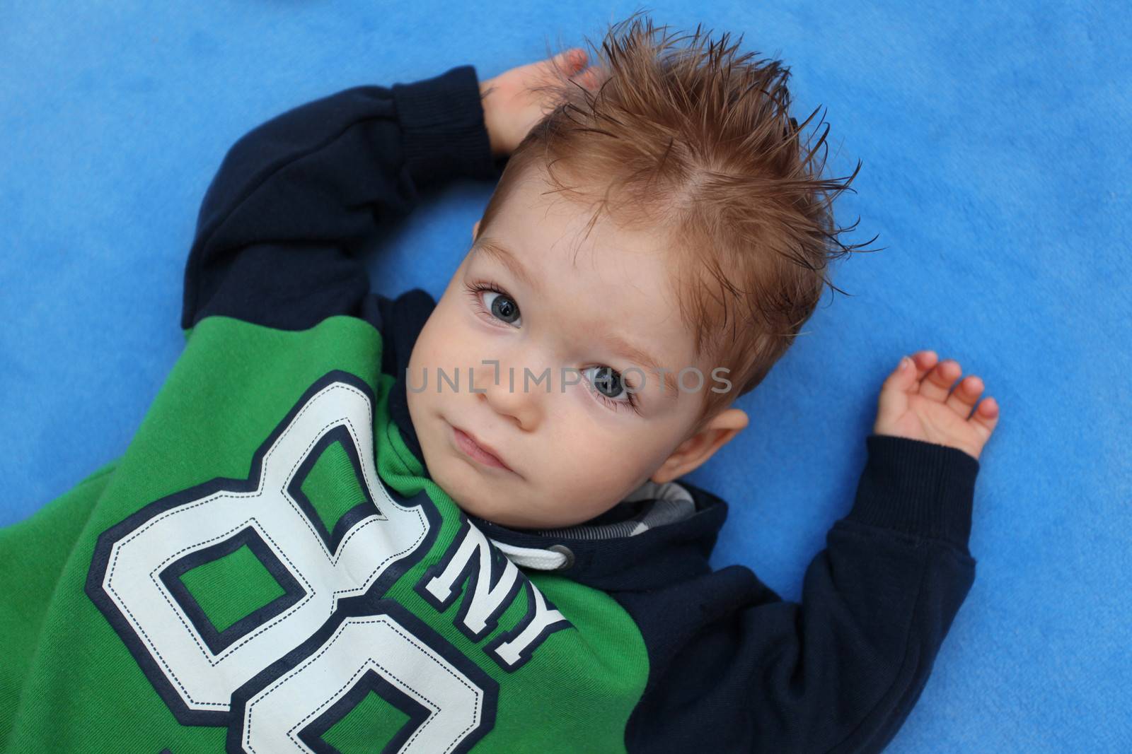 Portrait of little boy lying on floor 