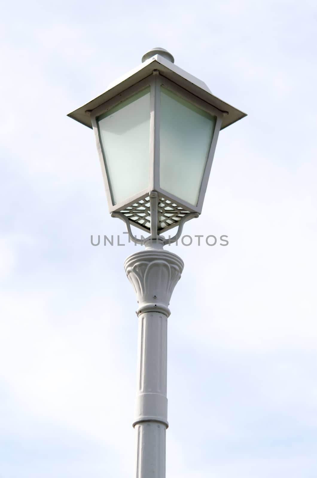 A single hooded street light with blue sky background