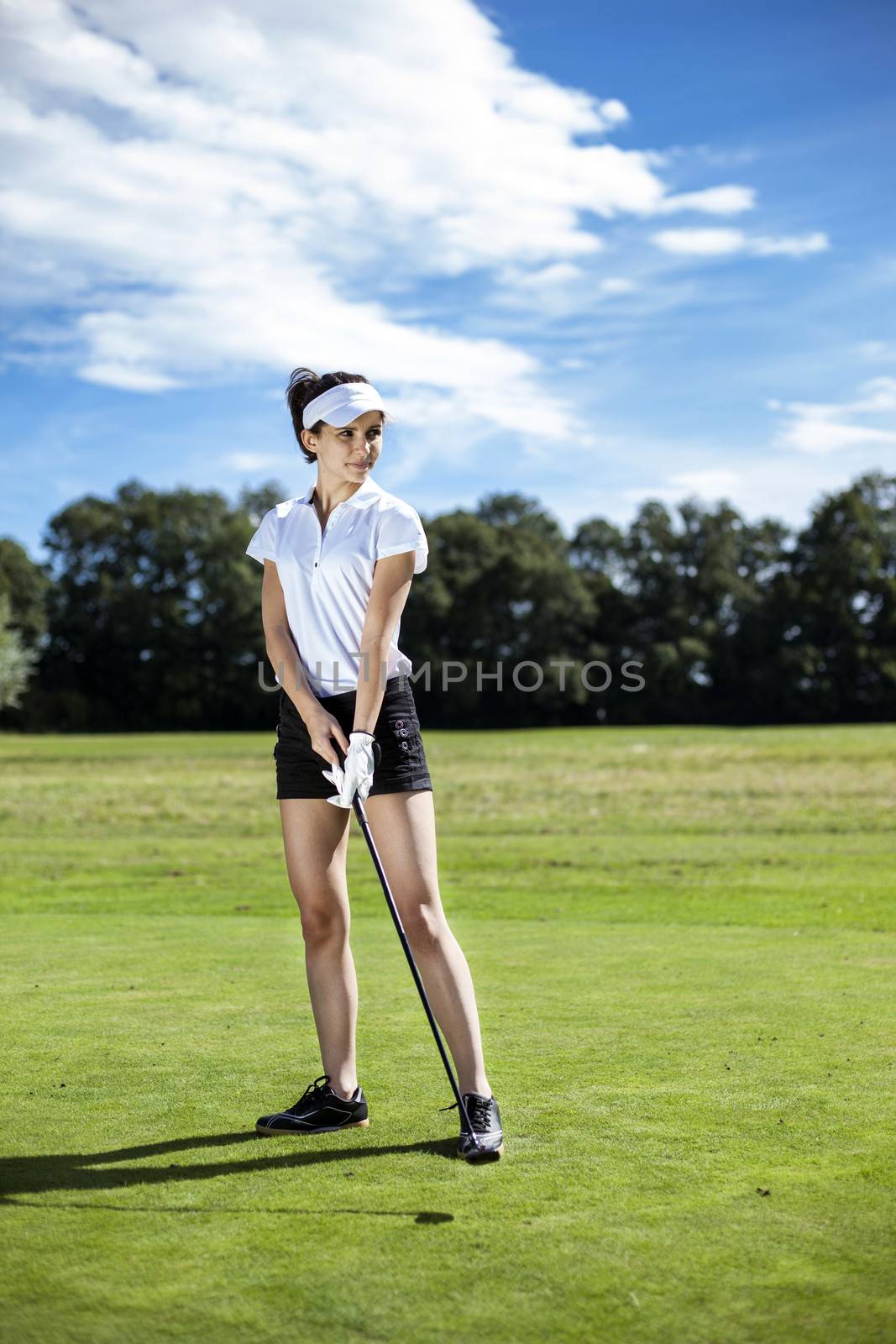 Pretty girl playing golf on grass by fikmik