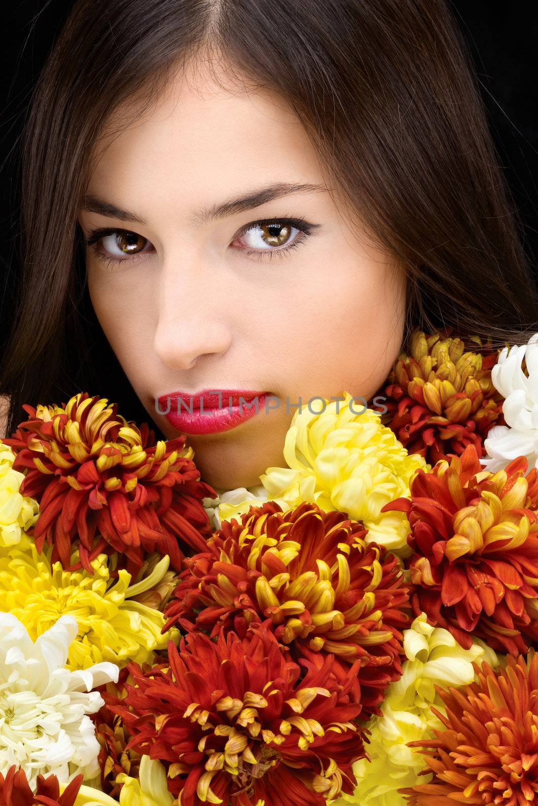 Pretty young brunette woman behind flowers