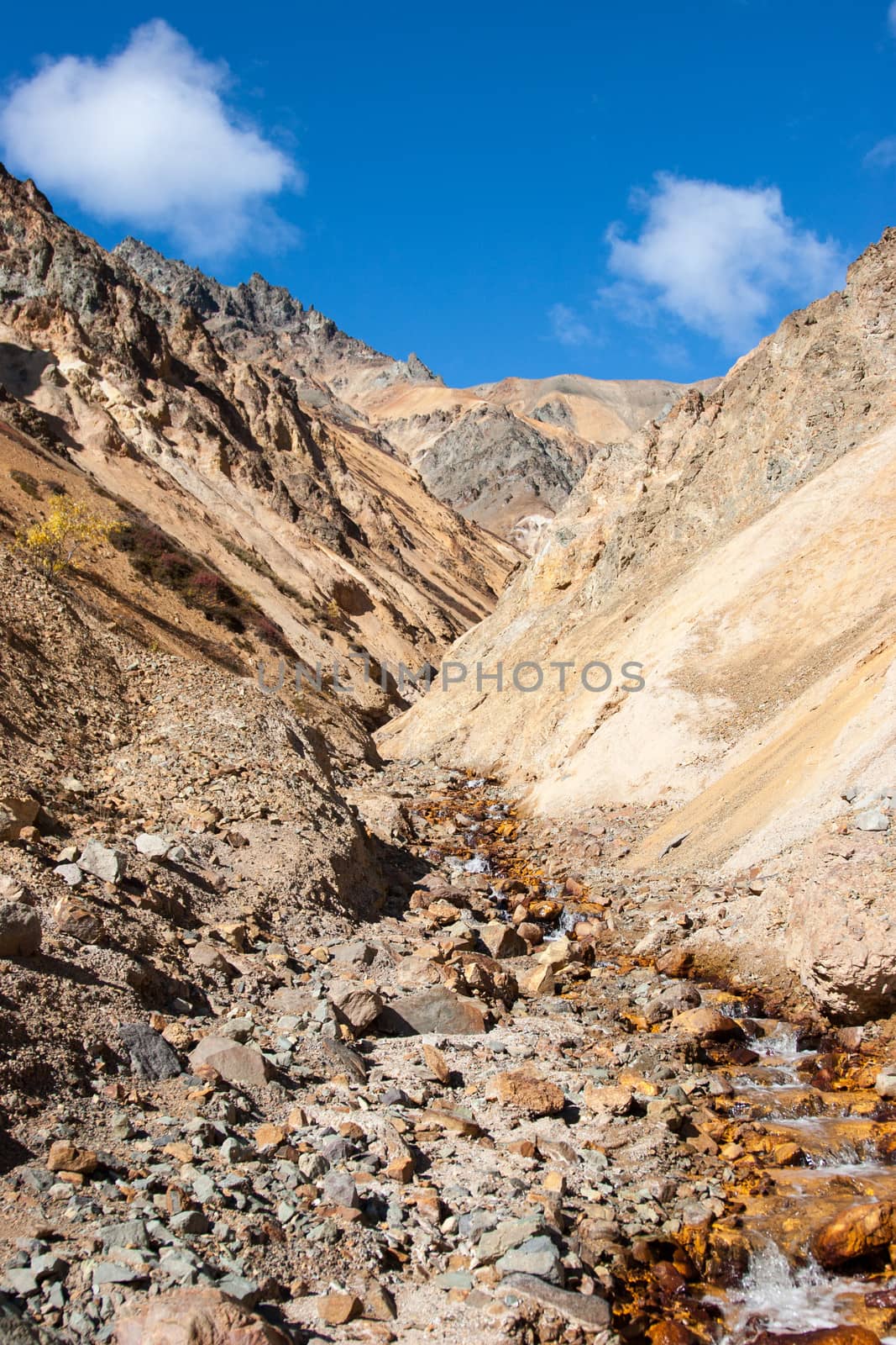 A small creek descends down steep mountain valley