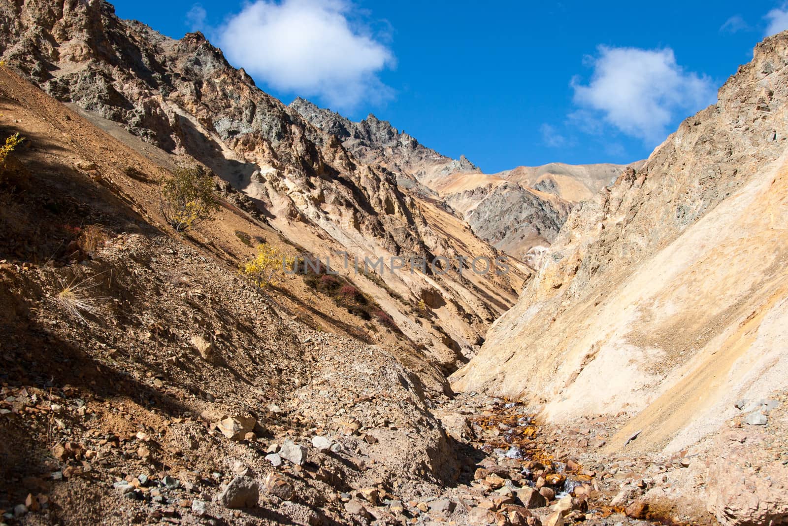 A small creek descends down steep mountain valley