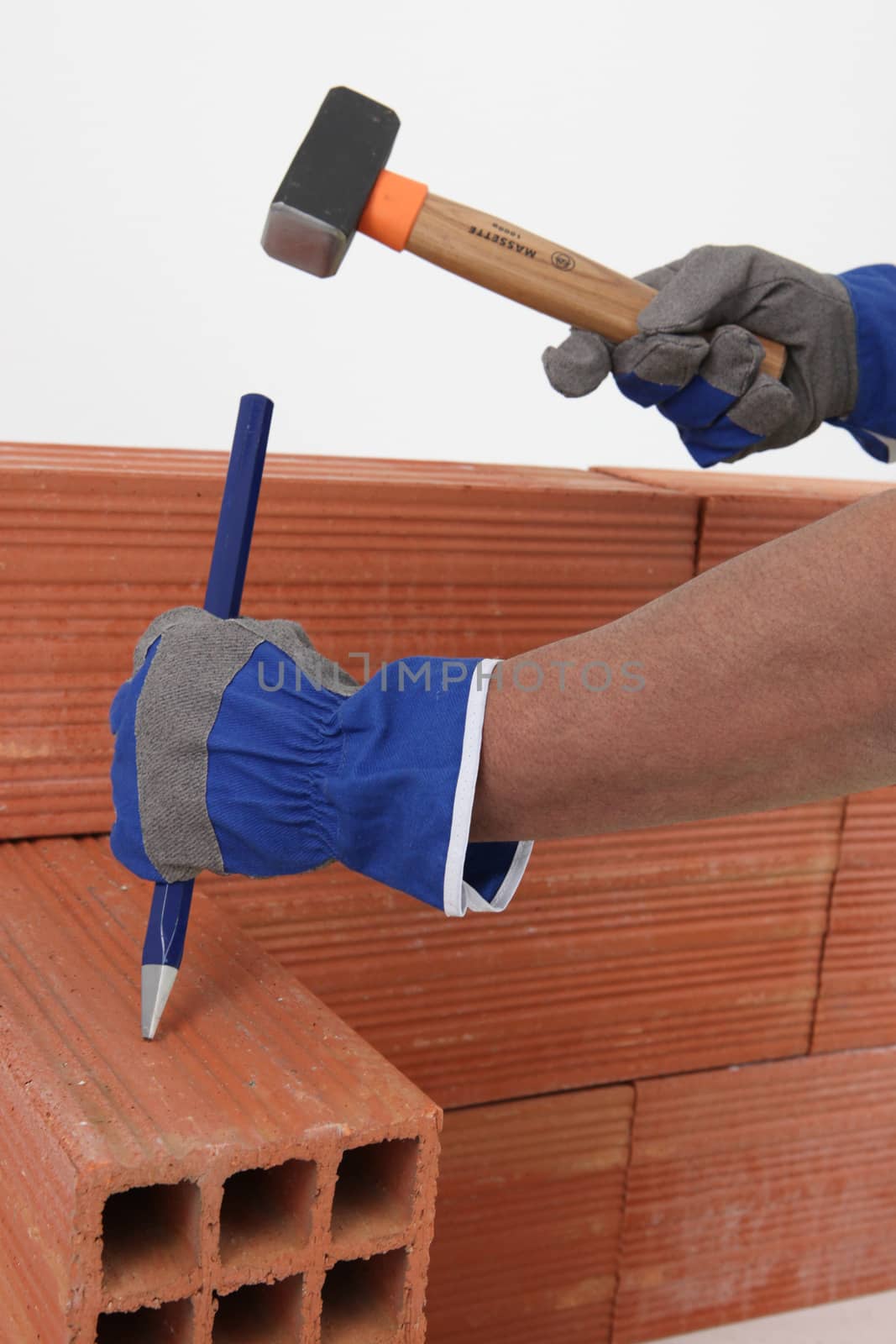 Builder chiseling a brick