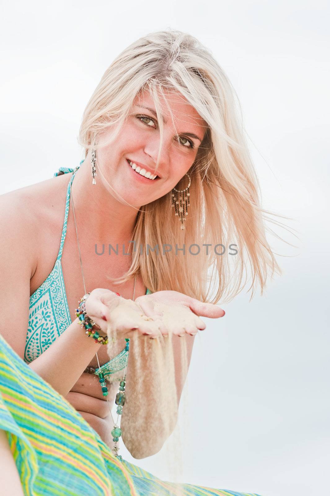 Blonde holds the sand on his hands.