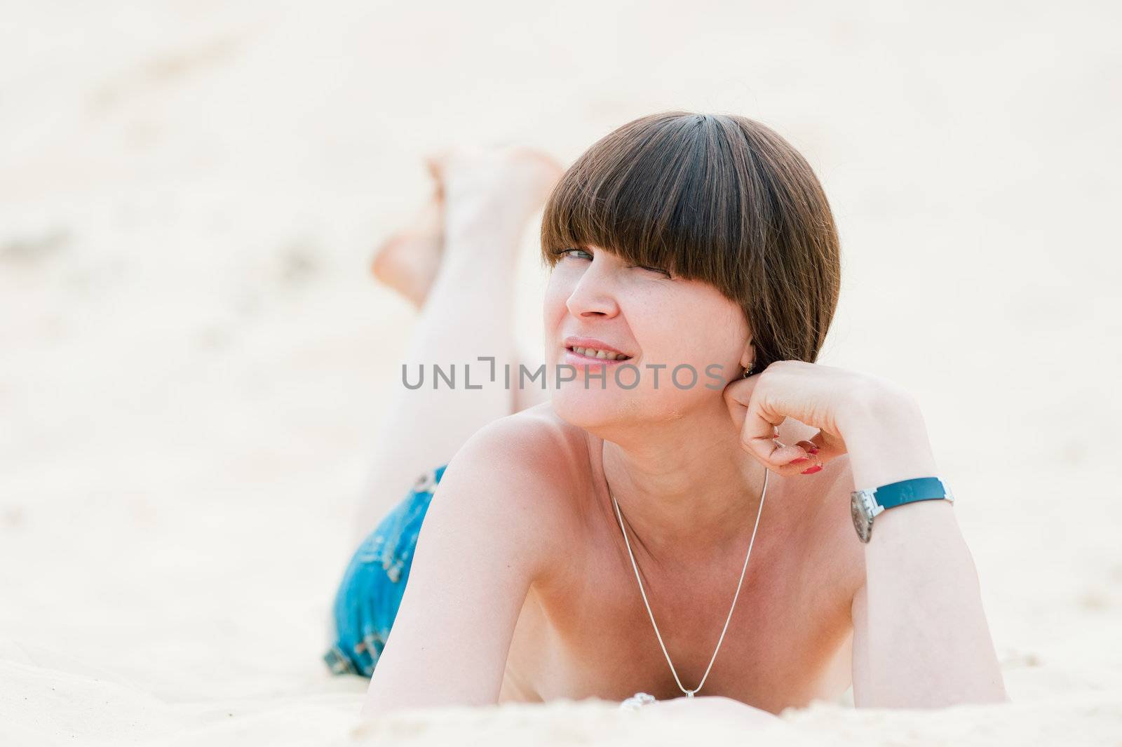 Brunette in jeans lying on the sand. by kosmsos111