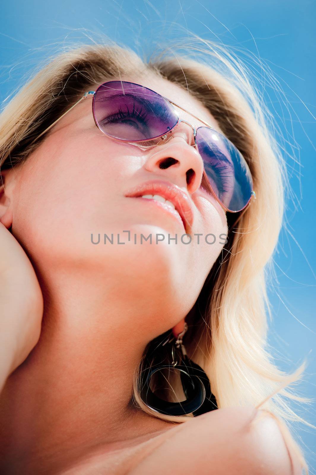 Portrait of a young woman wearing sunglasses, looking to the sky. by kosmsos111