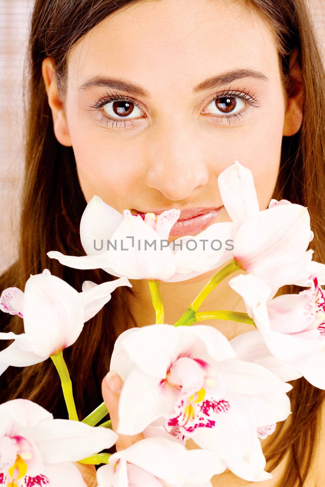 Pretty brunette woman behind white orchids