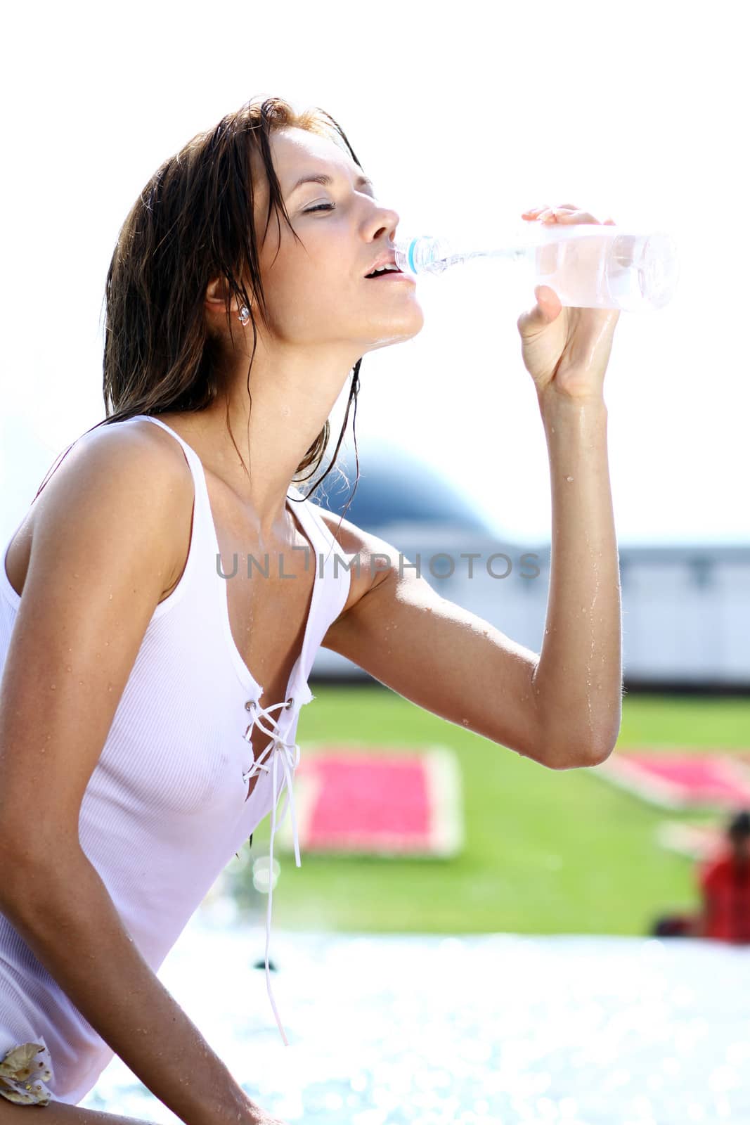 Sexy young woman drinking water from a bottle