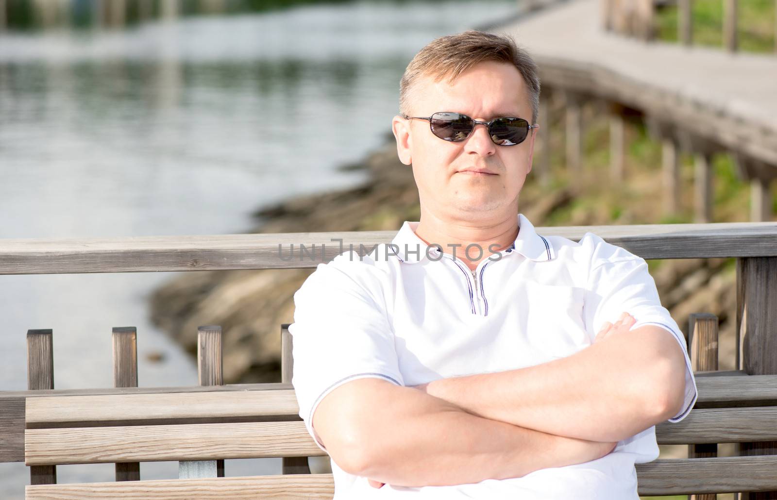 Middle aged men in sunglasses sitting on bench