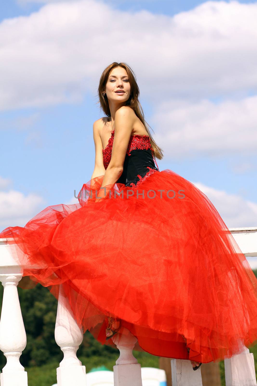 Young woman in a red gothic dress