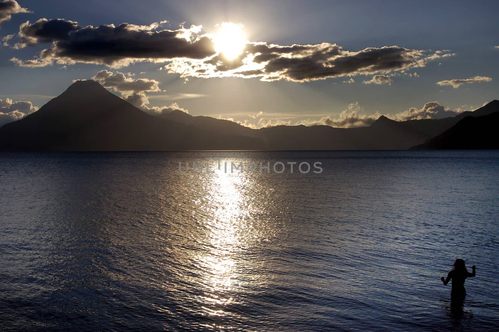  Volcanic Atitlan Lake in Guatemala with a woman at sunset