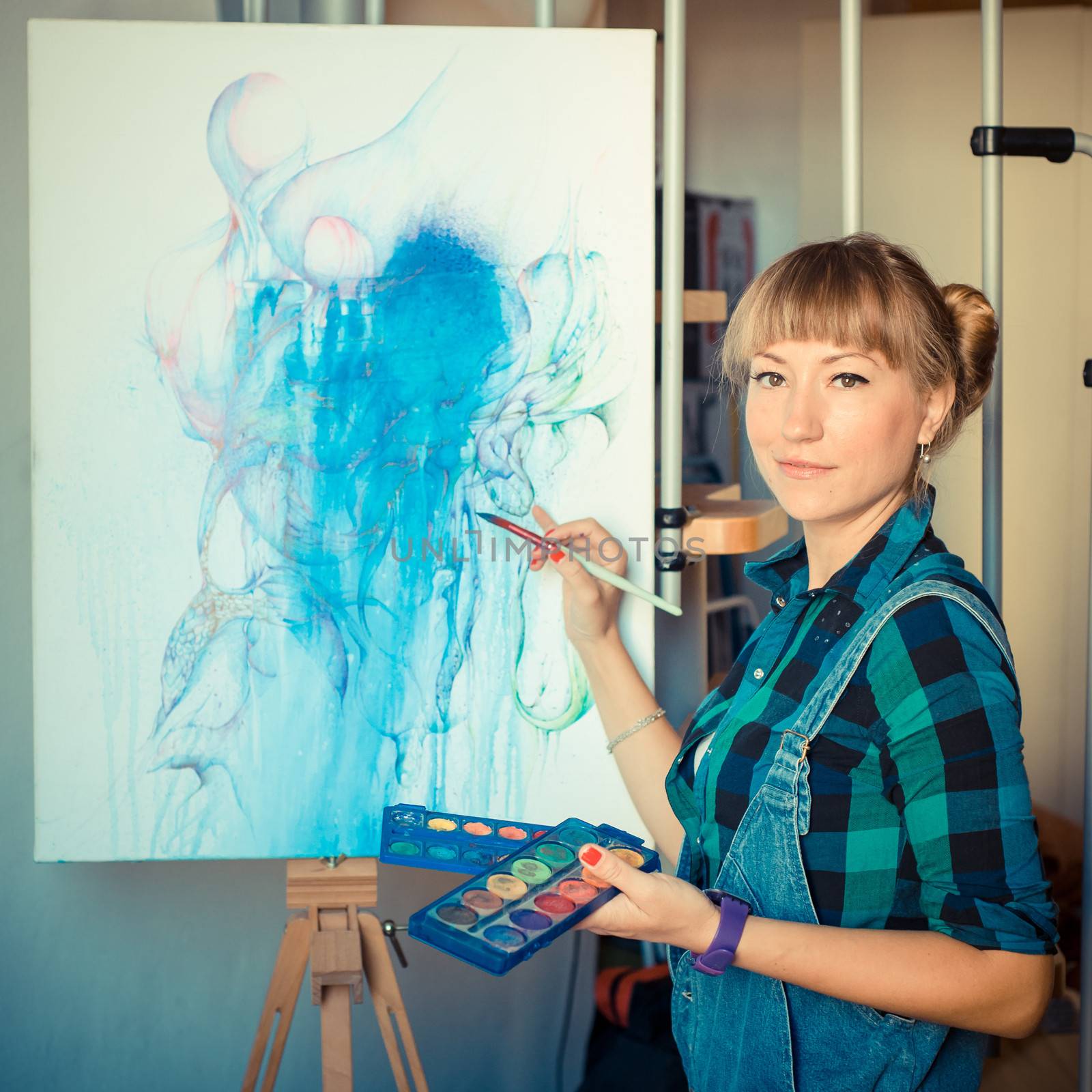 beautiful blonde woman painter in her studio