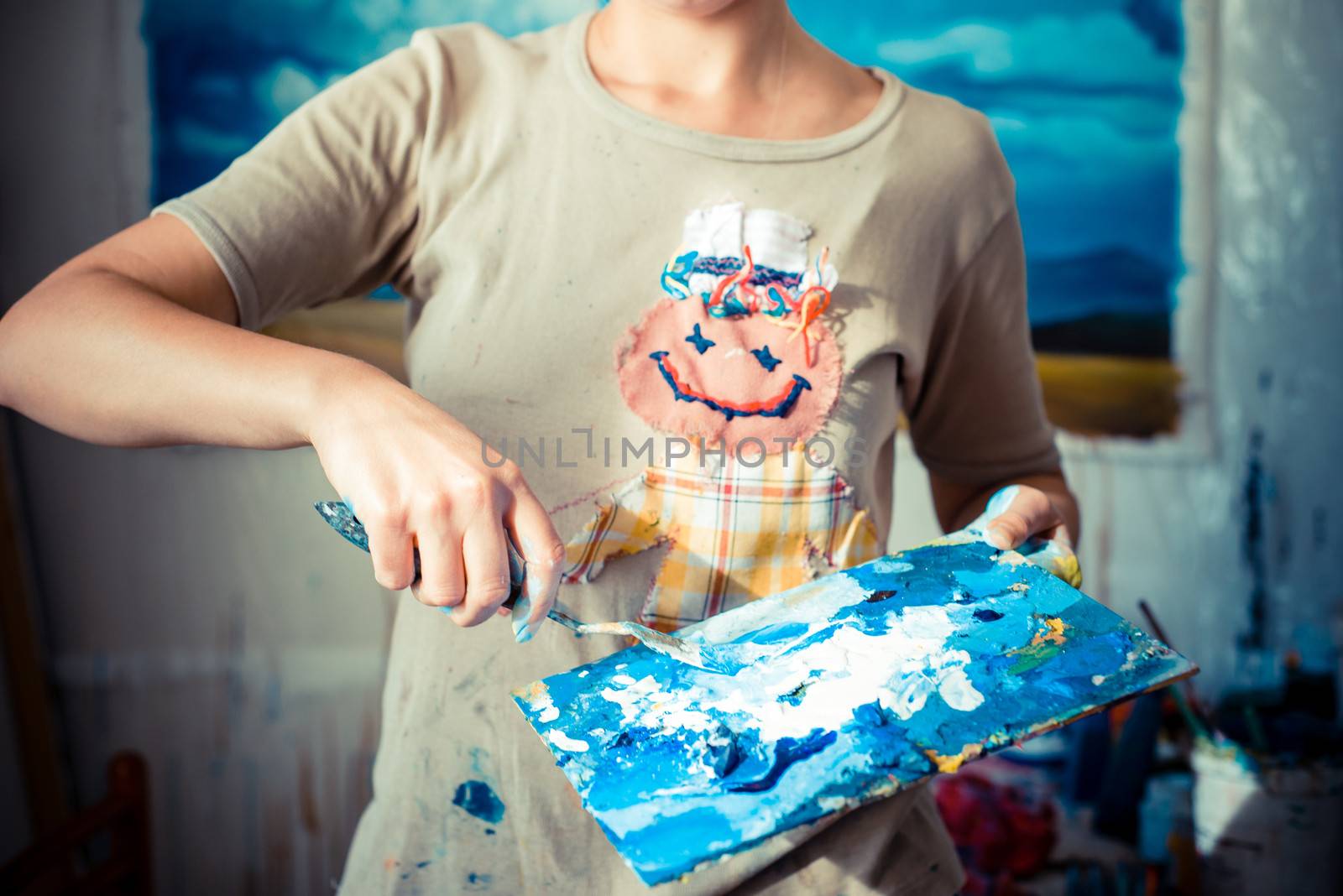 particular of woman painter hand painting in her studio