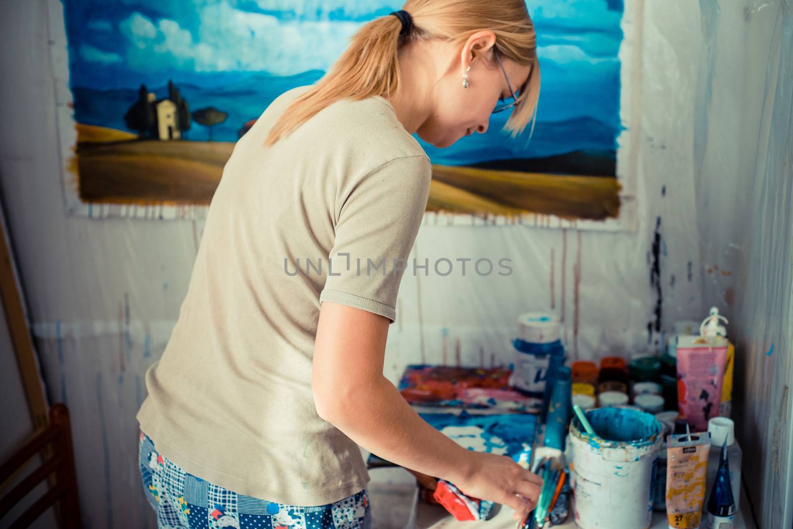 beautiful blonde woman painter in her studio