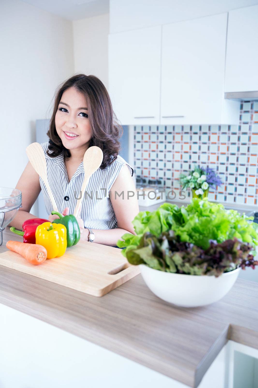 Portrait of beautiful relaxed young woman standing at the kitchen counter