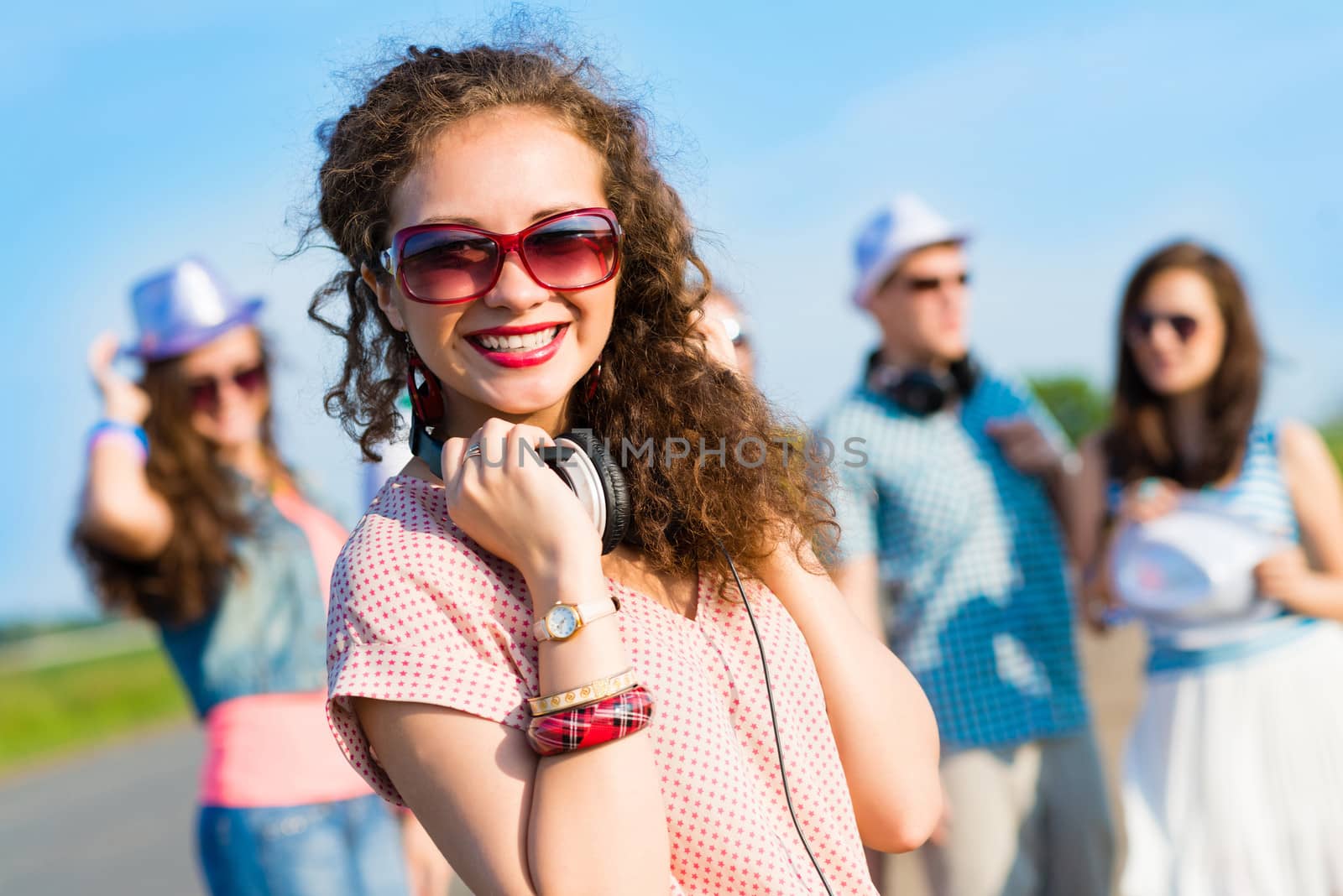 young woman with headphones on a background of blue sky and funny friends