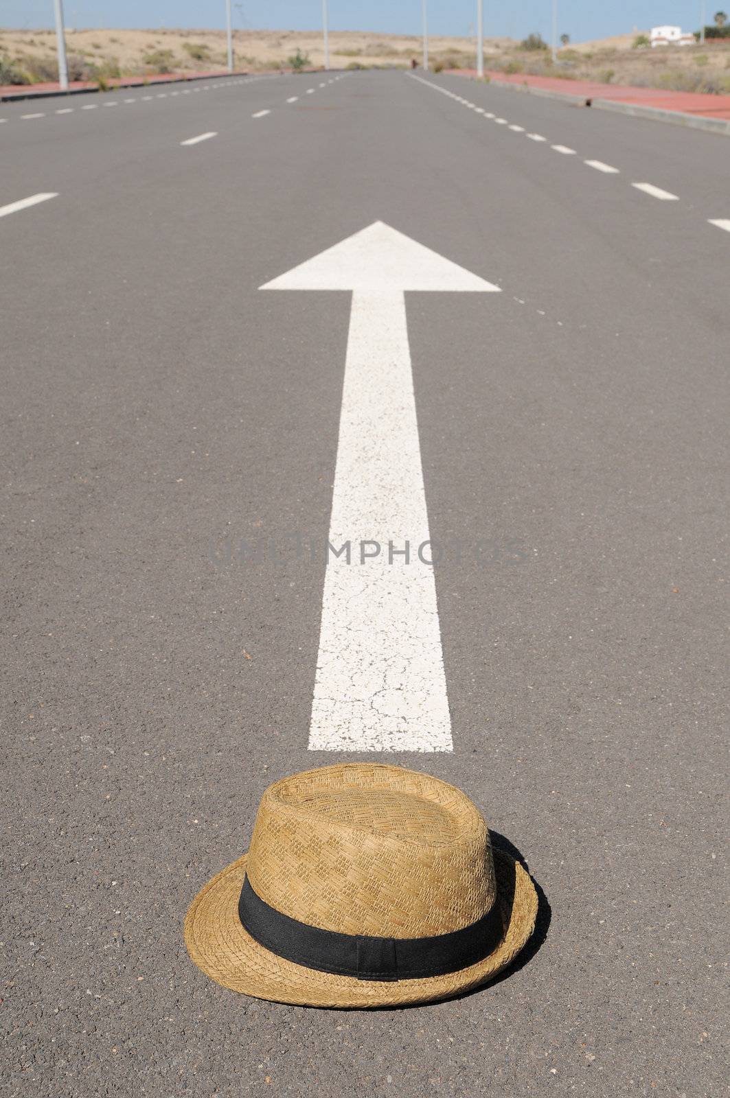 Hat on an arrow on a asphalt street to the future