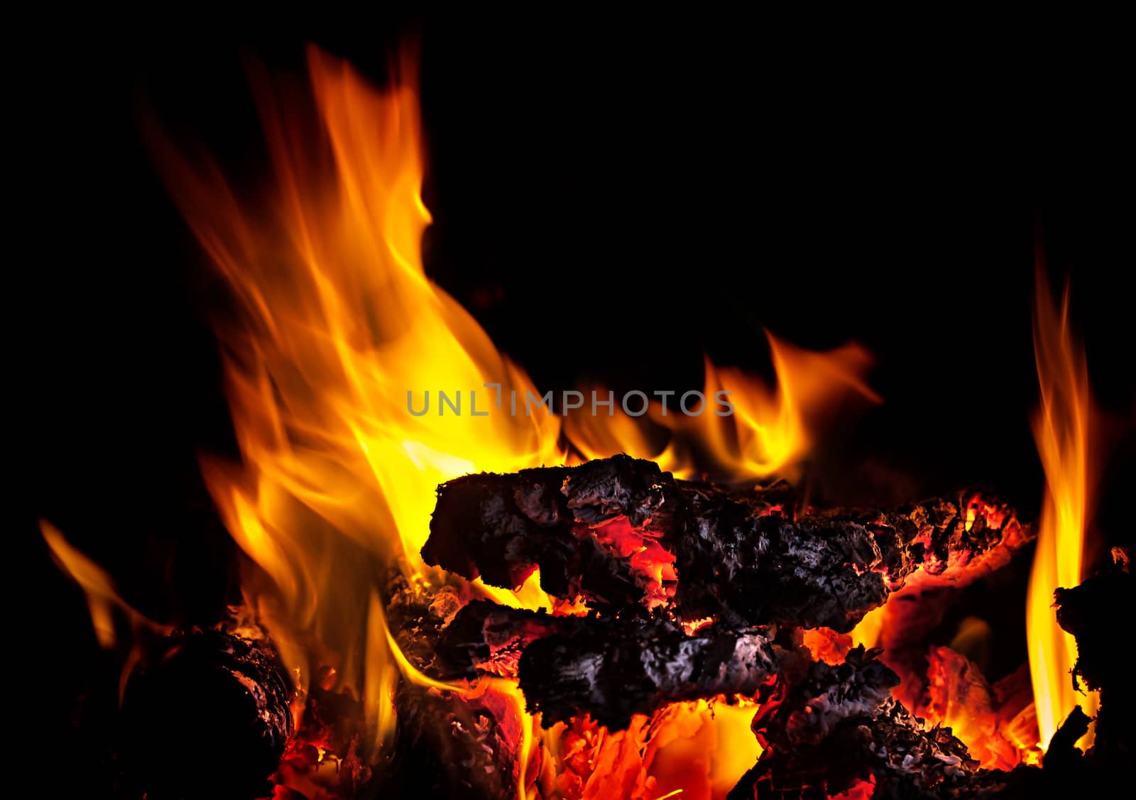 Live coals with fire flames on black background