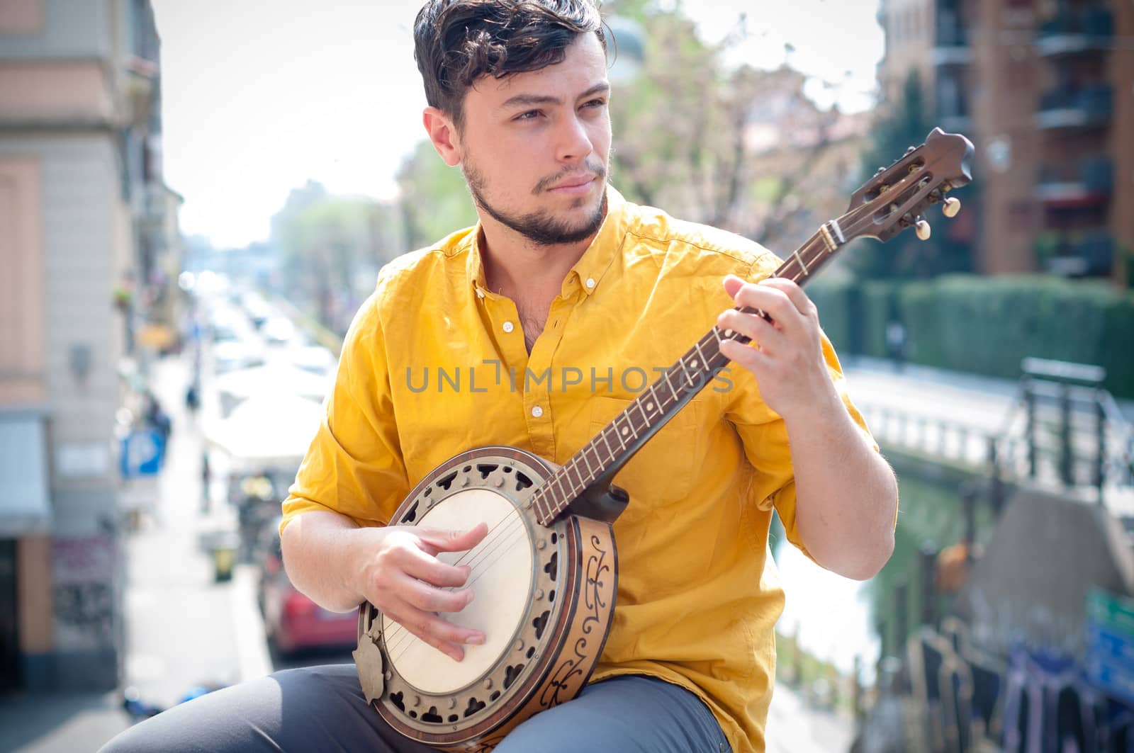 hipster young man playing banjo in the city