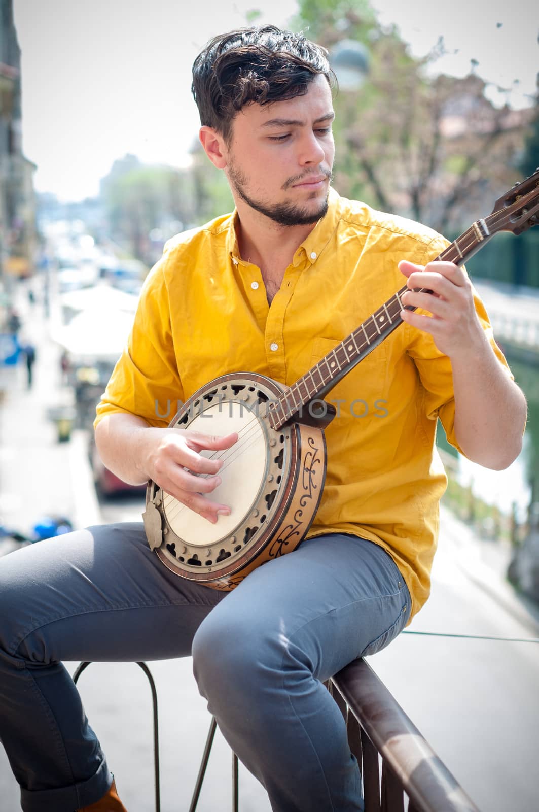 hipster young man playing banjo in the city