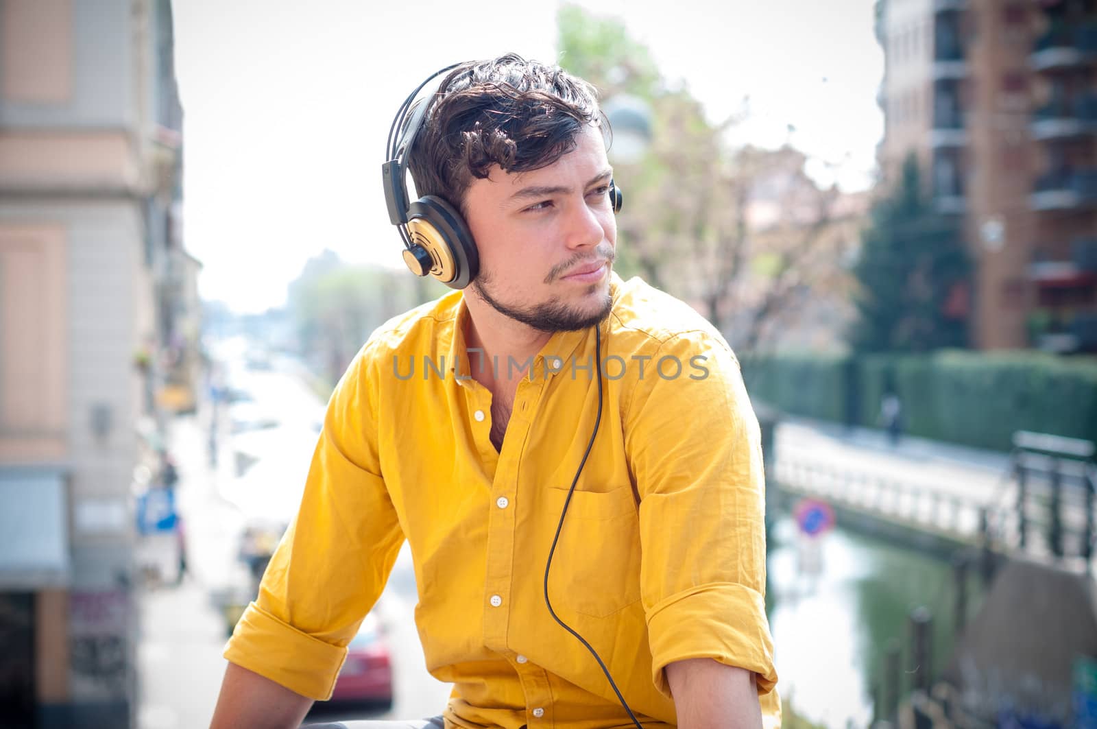 hipster young man listening to music on the balcony 