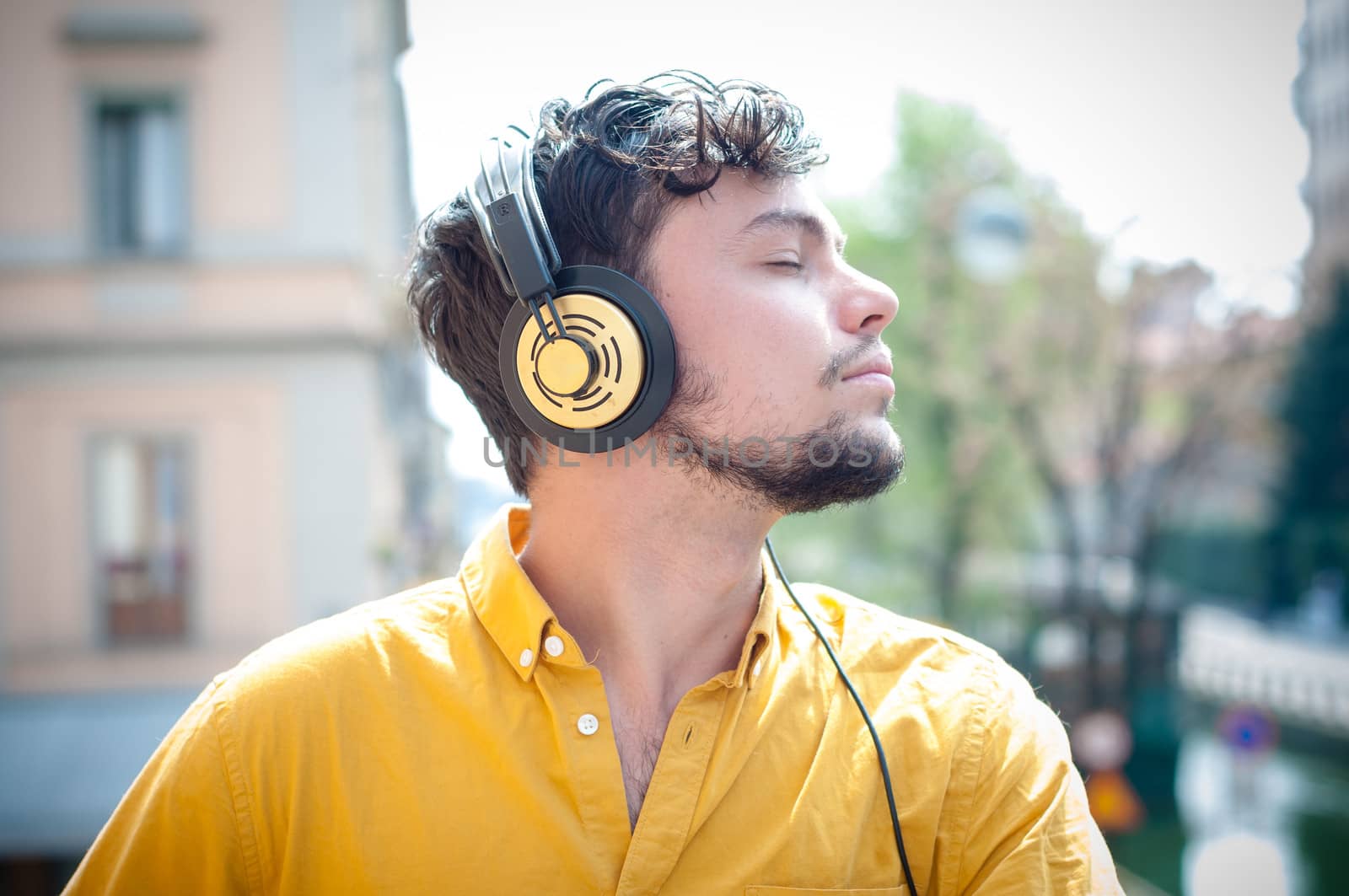 hipster young man listening to music on the balcony 