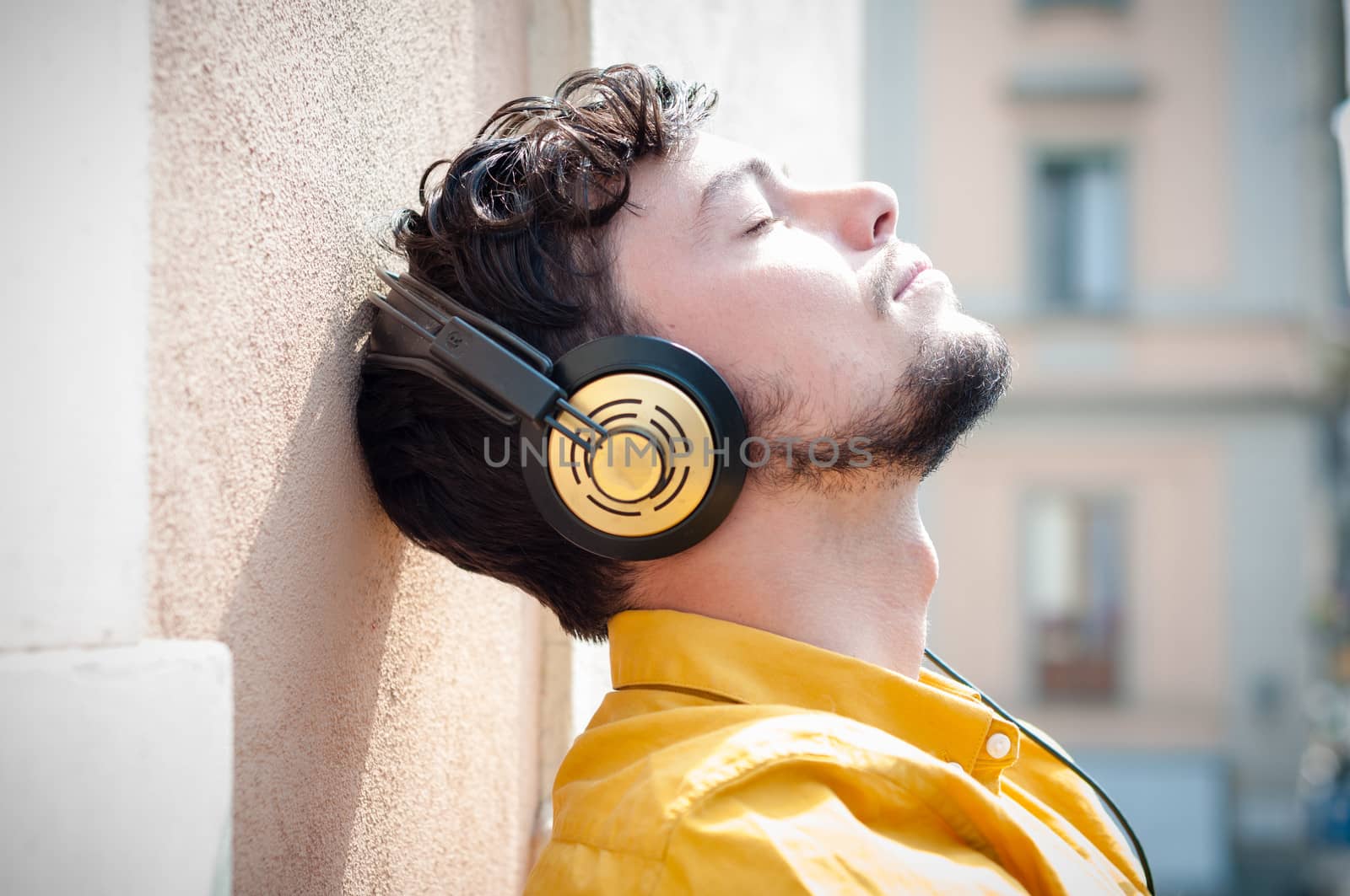 hipster young man listening to music on the balcony 
