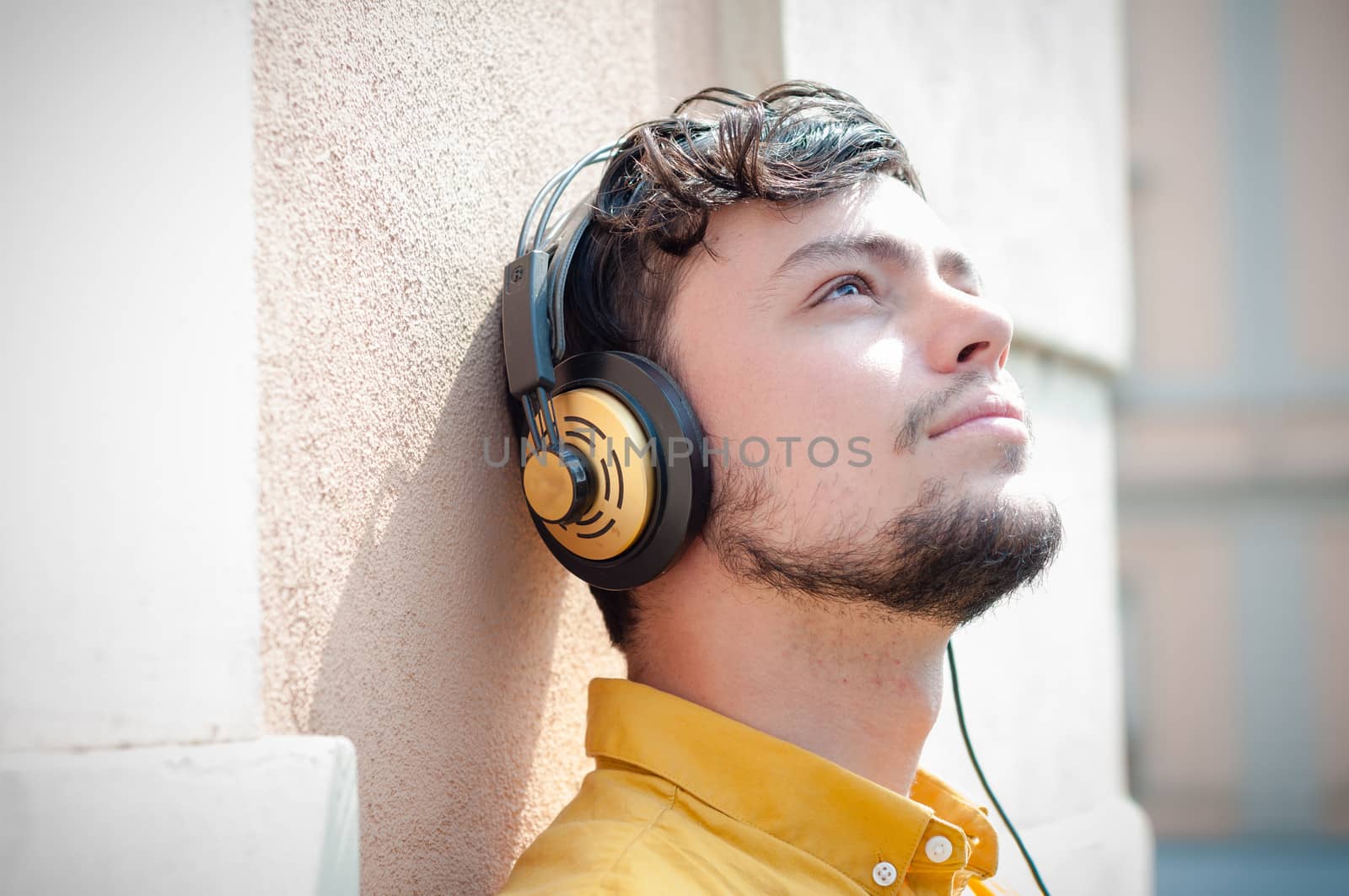 hipster young man listening to music on the balcony 