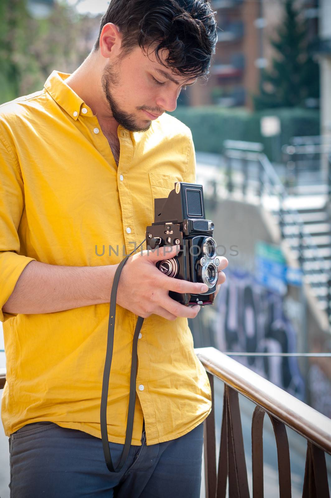 hipster young man with old camera on the balcony