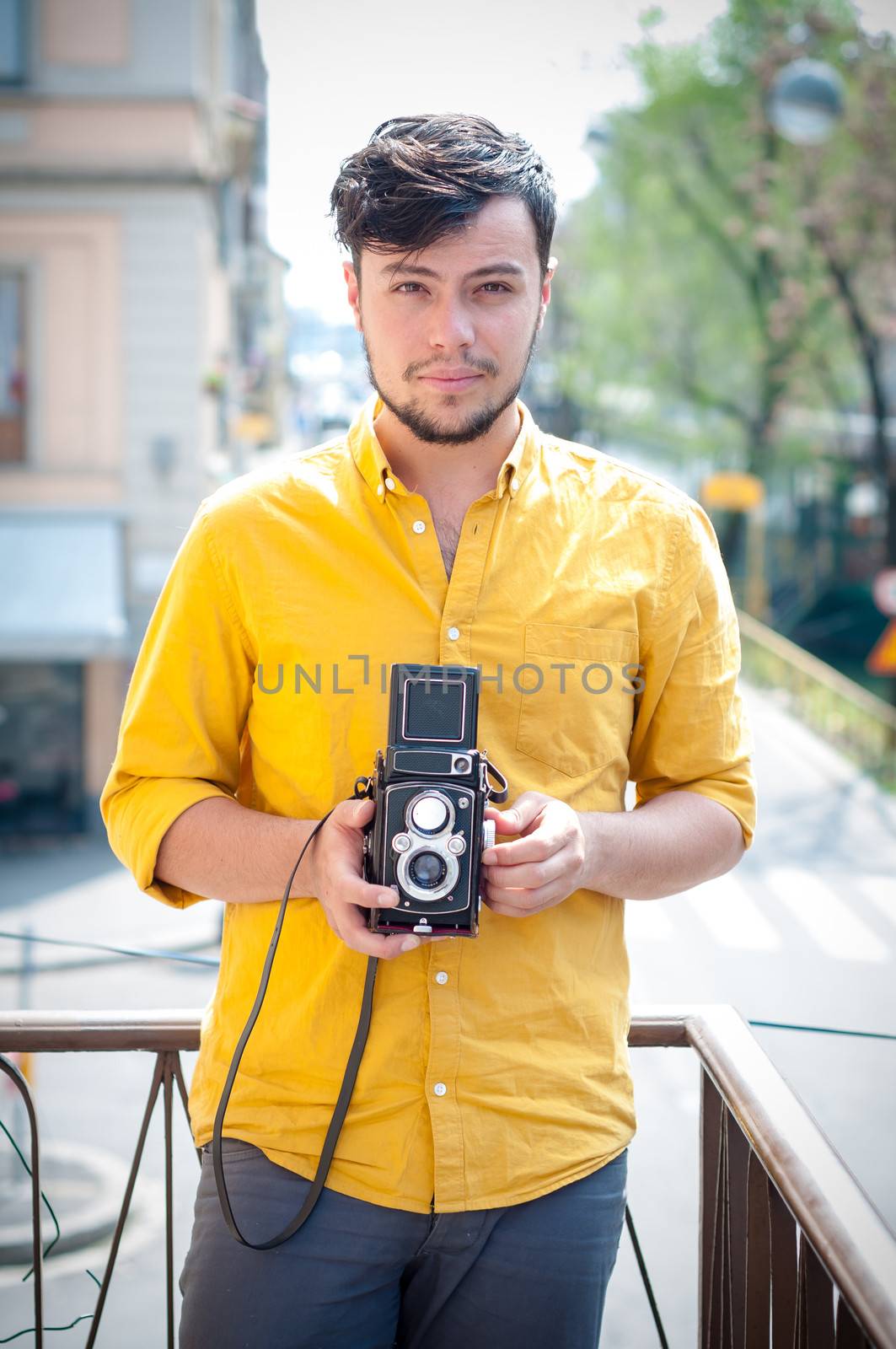 hipster young man with old camera on the balcony