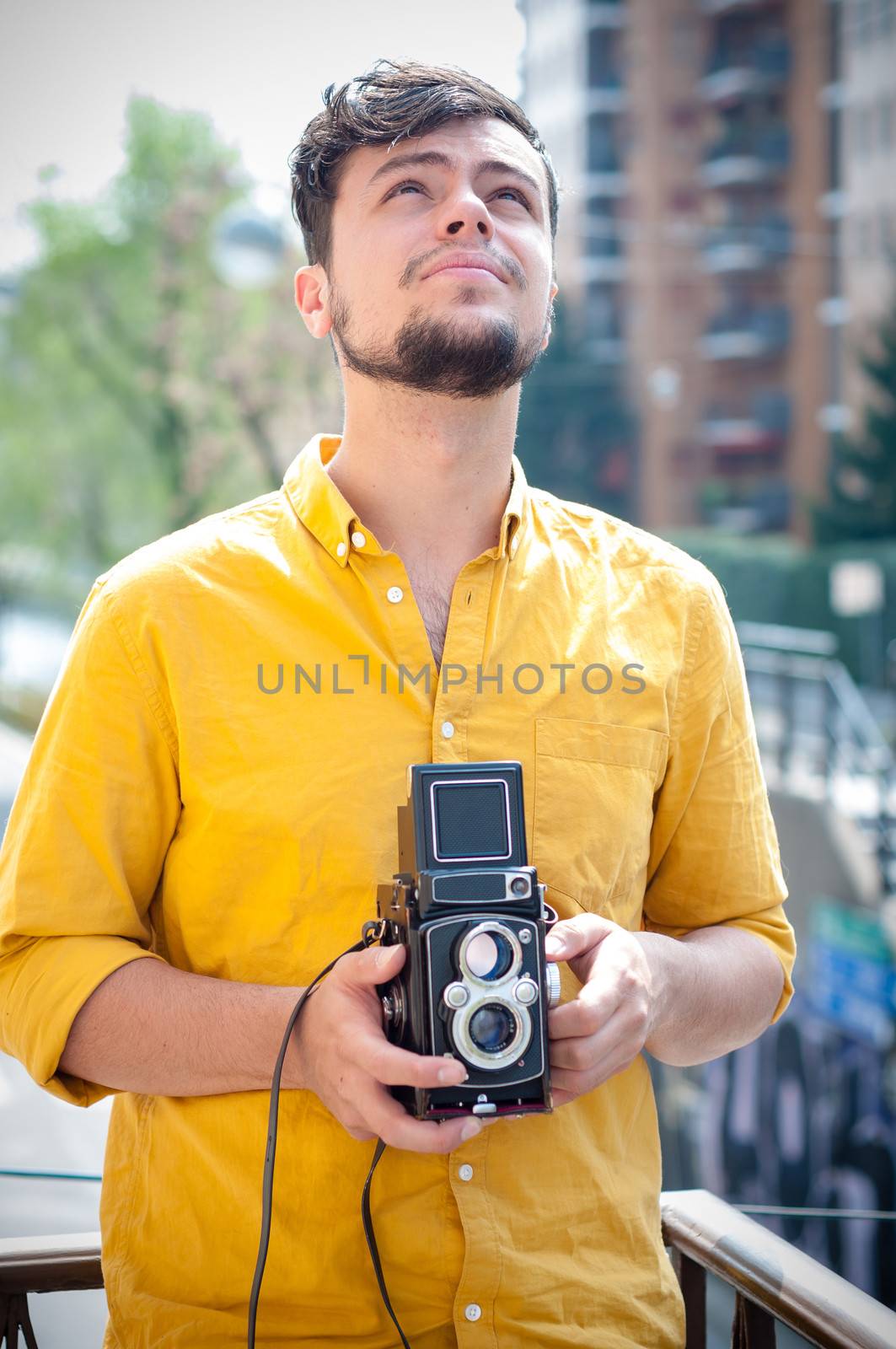 hipster young man with old camera on the balcony