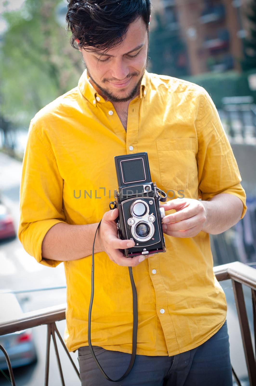 hipster young man with old camera on the balcony