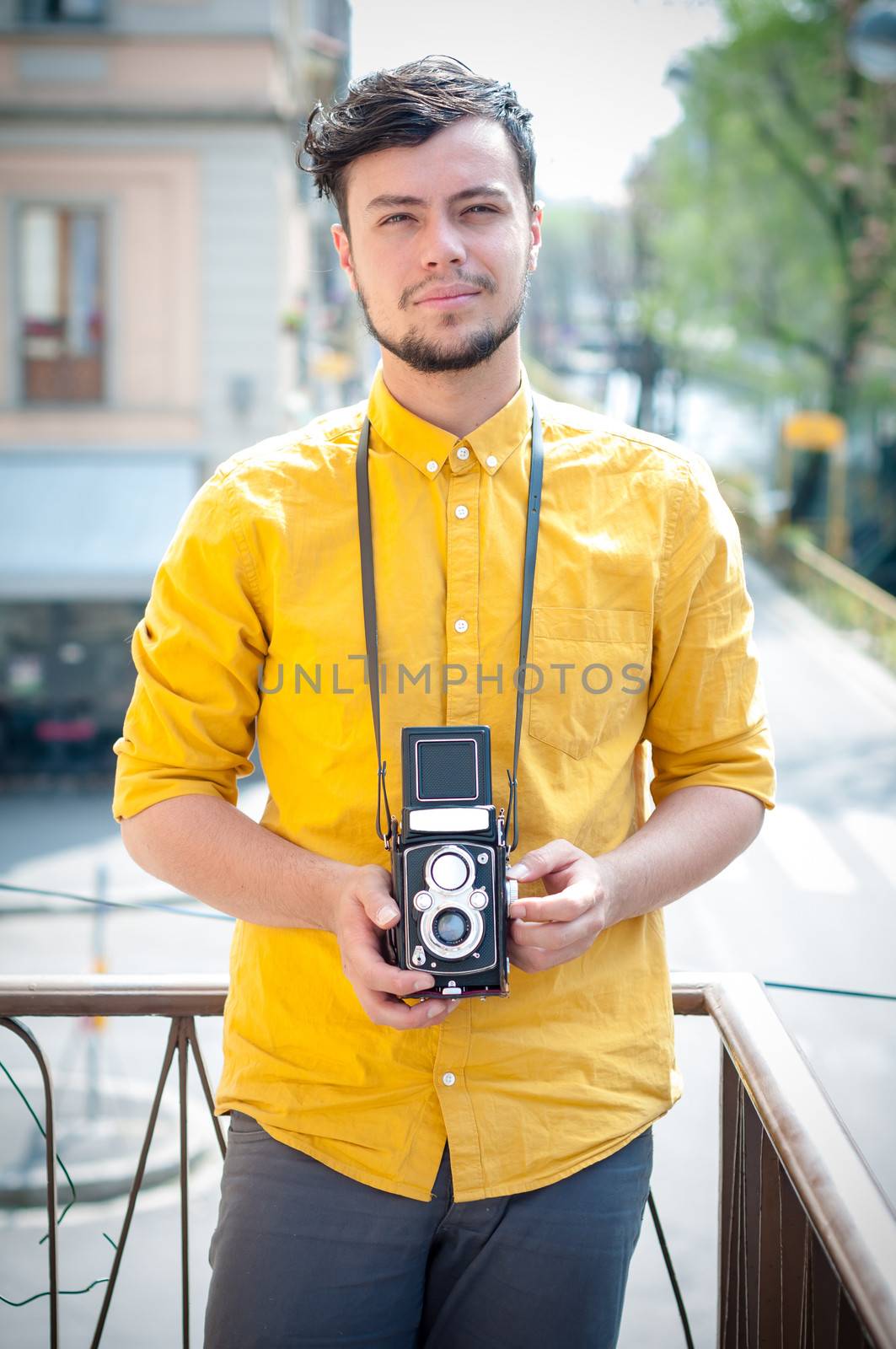 hipster young man with old camera on the balcony
