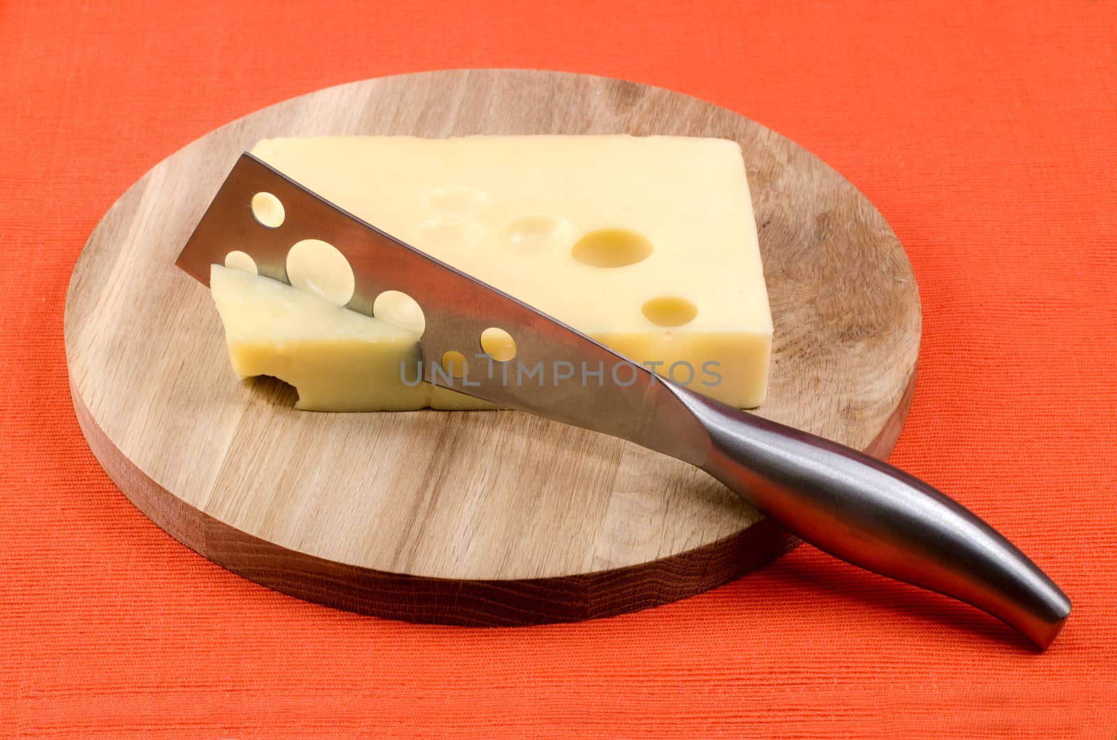 Cheese with a knife on a wooden board