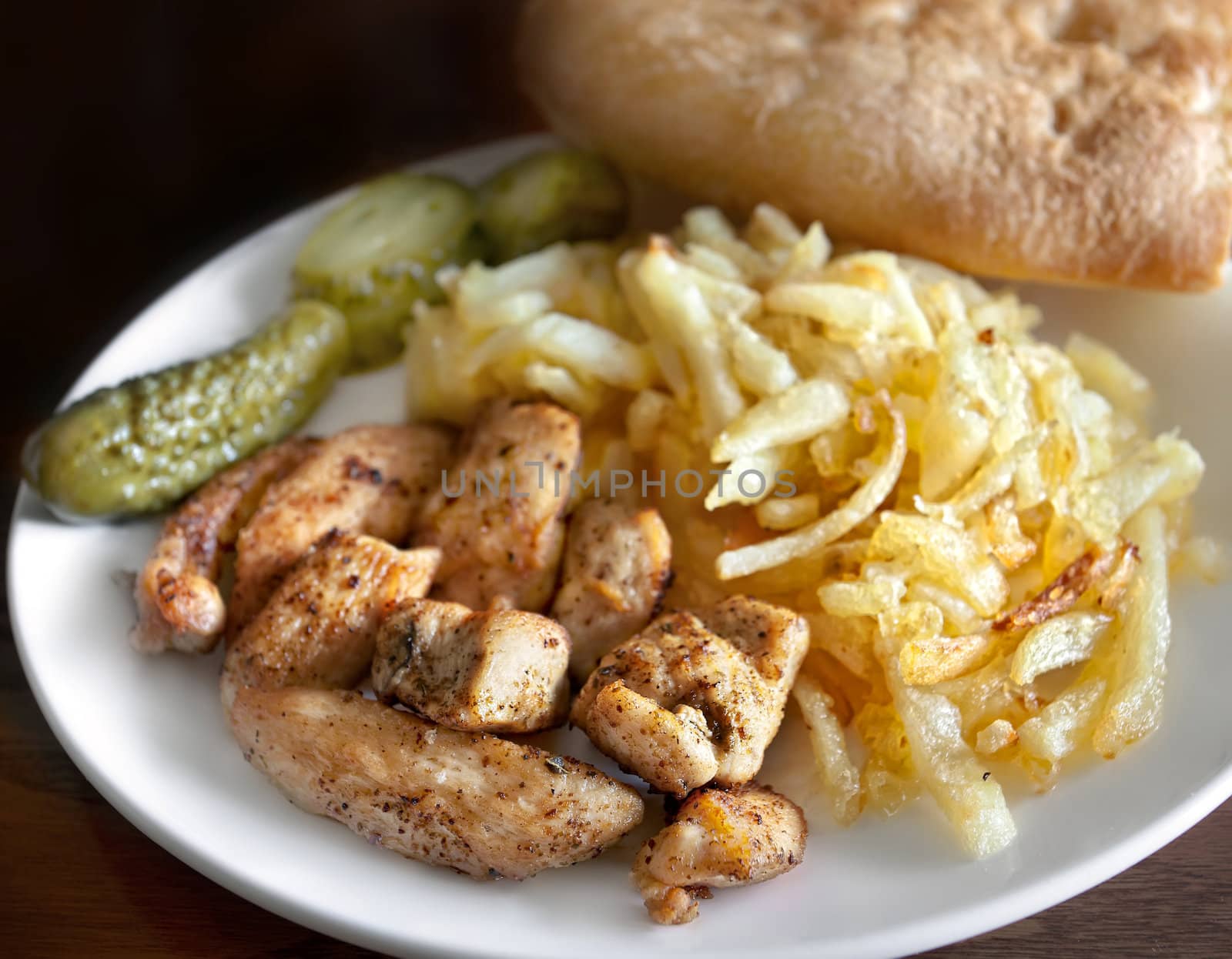 Plate with roast chicken meat and potatoes. Focus mainly on meat