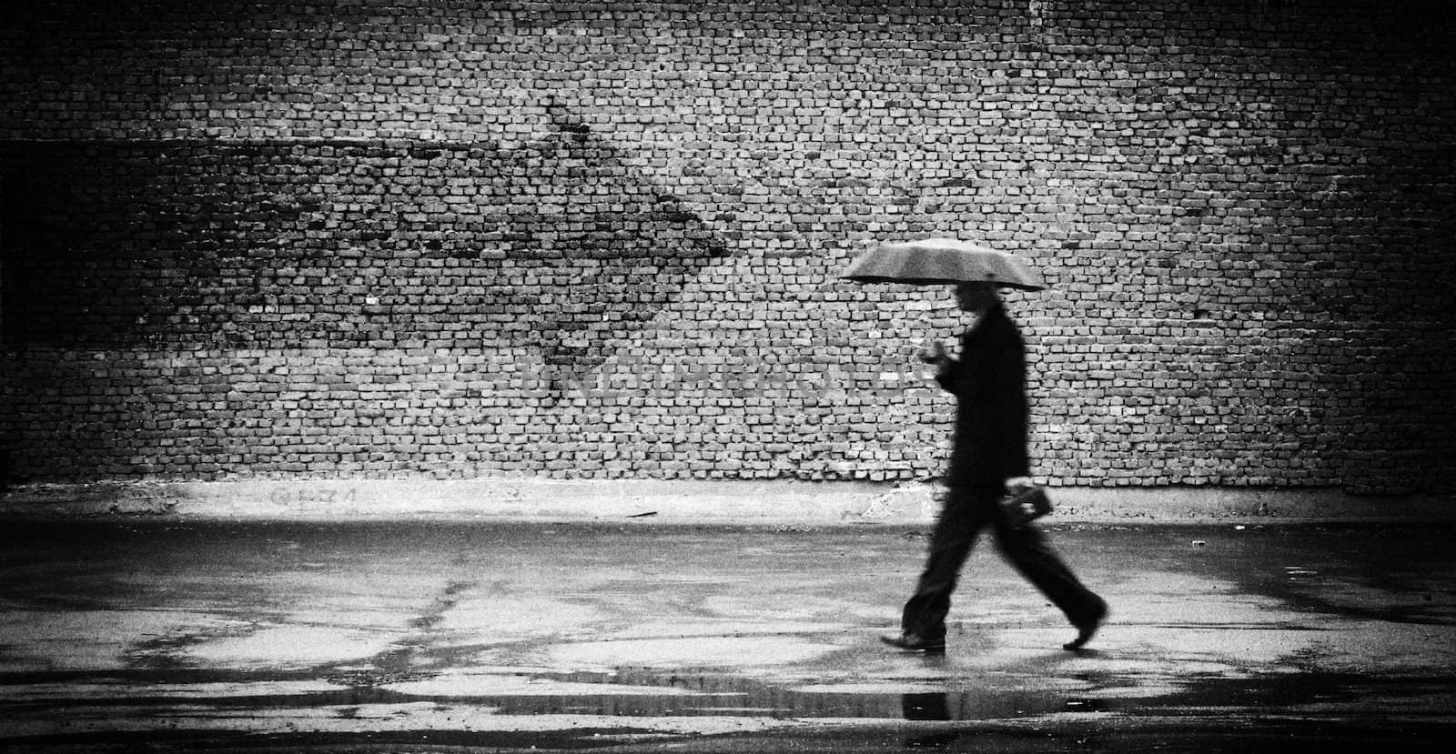 Wrong way. A man with umbrella. Conceptual image, film grain added