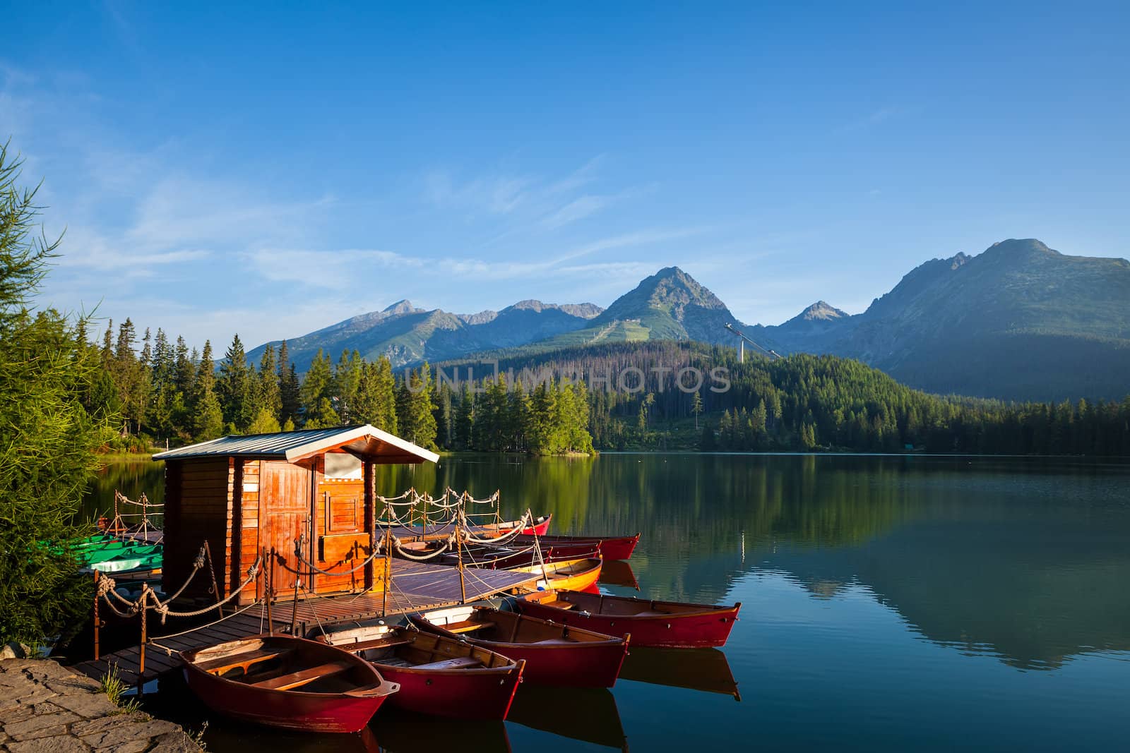 Red boats on mountain lake in National Park High Tatra. Strbske pleso, Slovakia, Europe