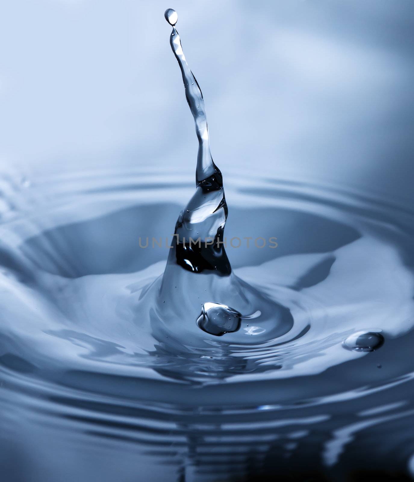 Drop of water in blue. Splash of water close up